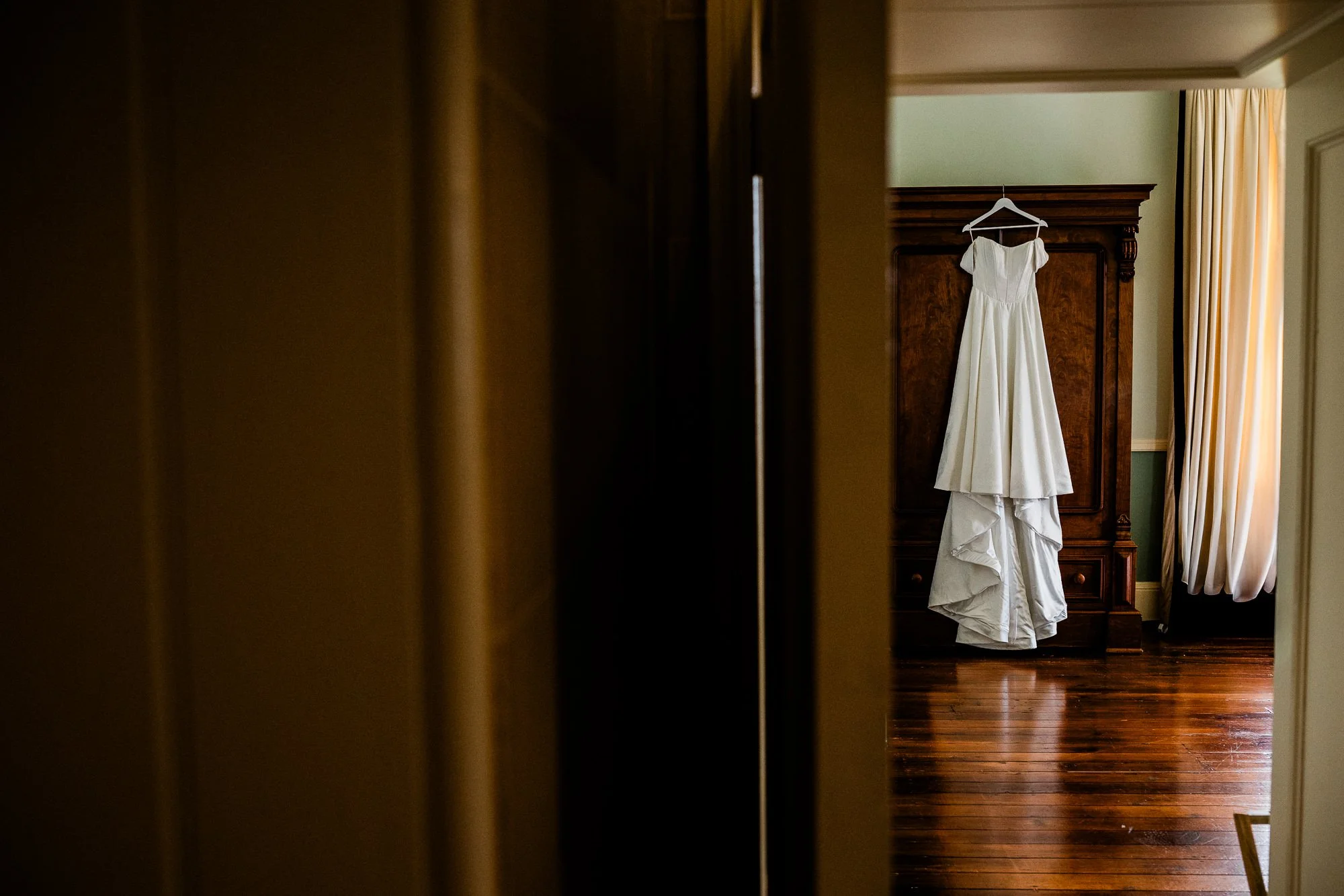 Aimee’s wedding dress hanging in a doorway inside Kinmount House.