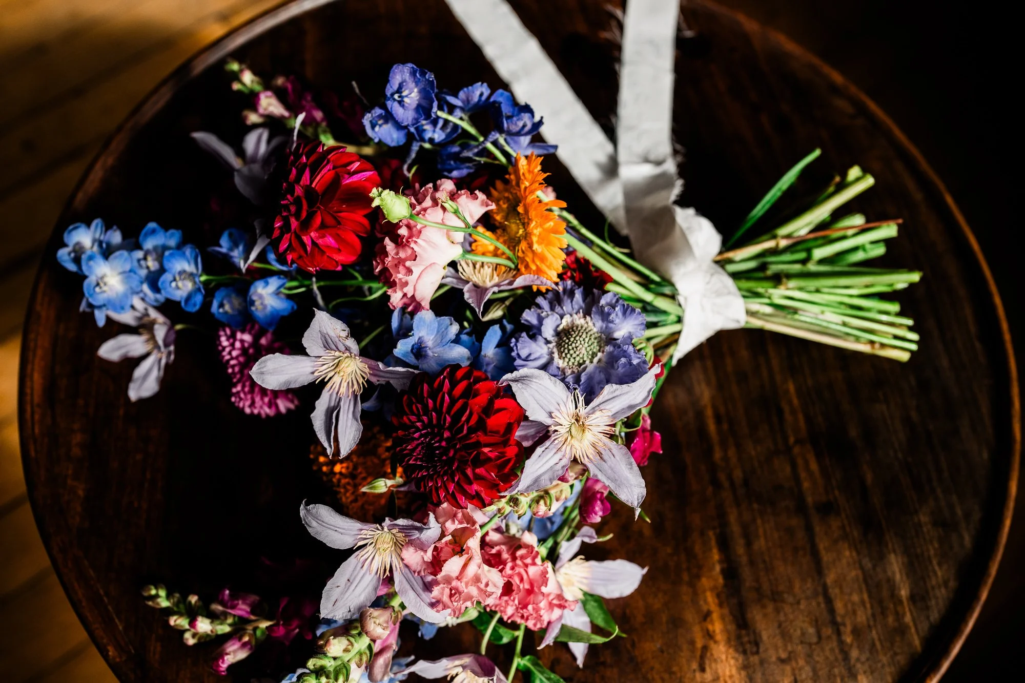 A colourful bridal bouquet arranged on a wooden table.