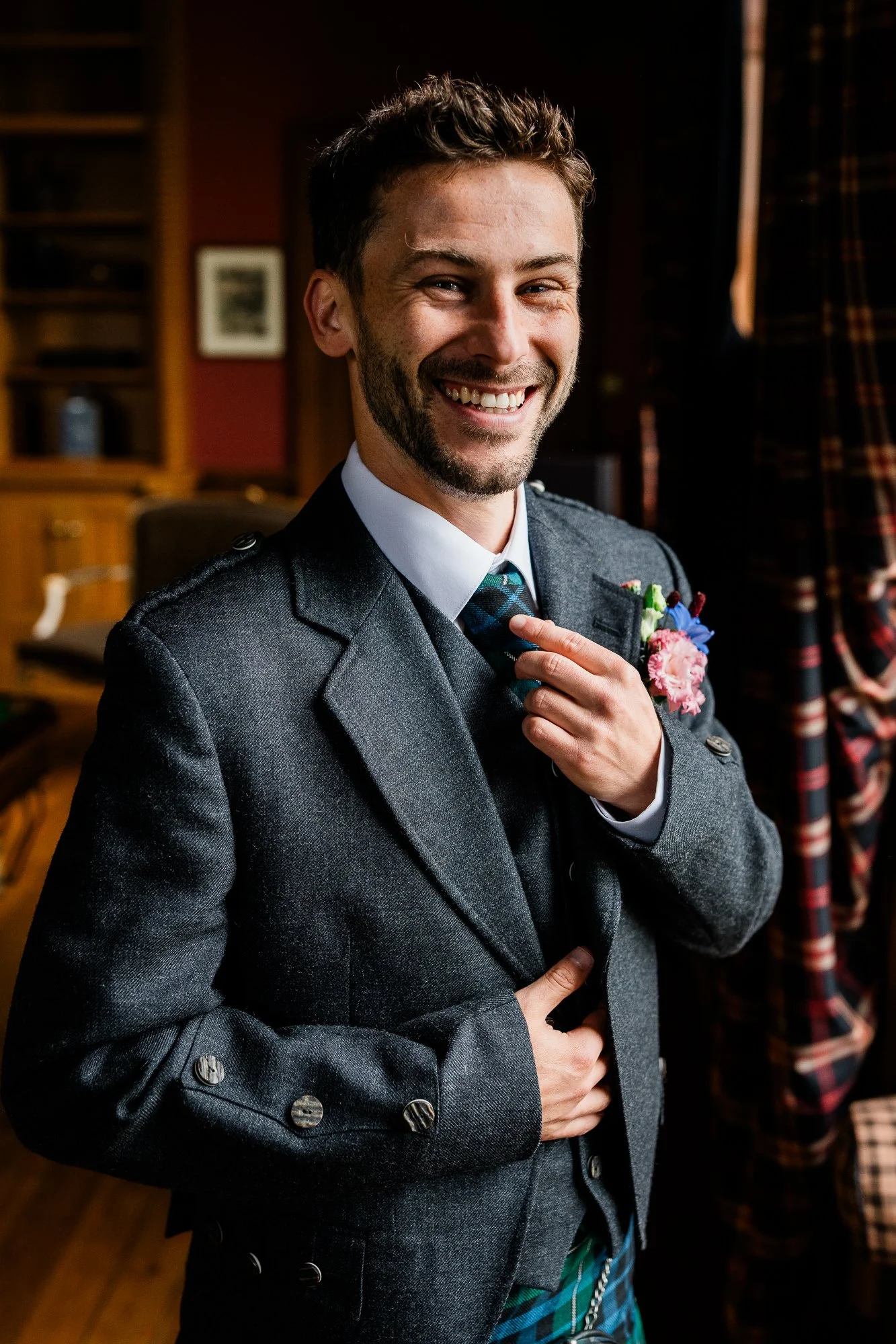 Matthew smiles while adjusting his wedding outfit before the ceremony.