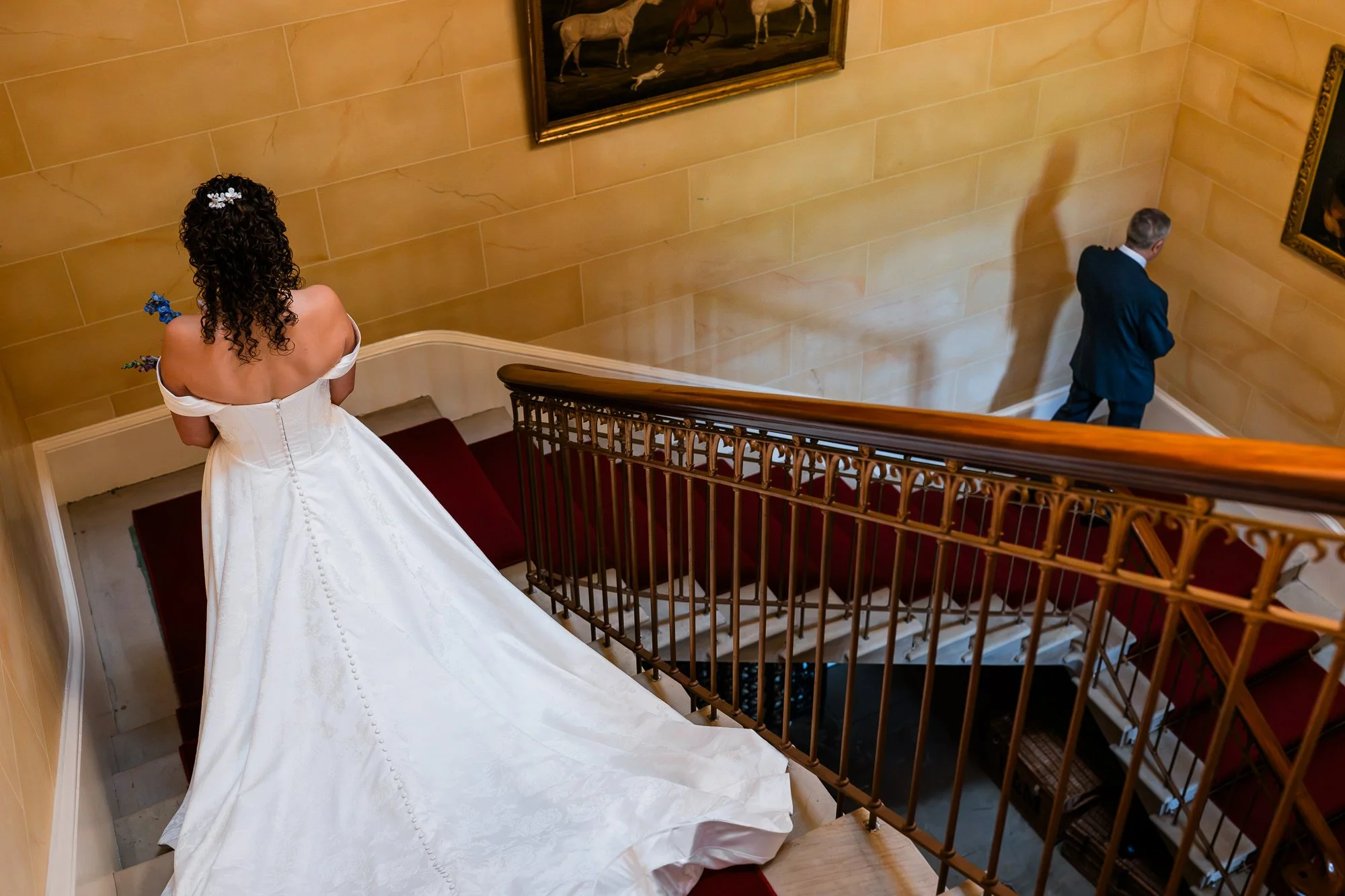 Aimee descends the staircase in her wedding dress at Kinmount House.
