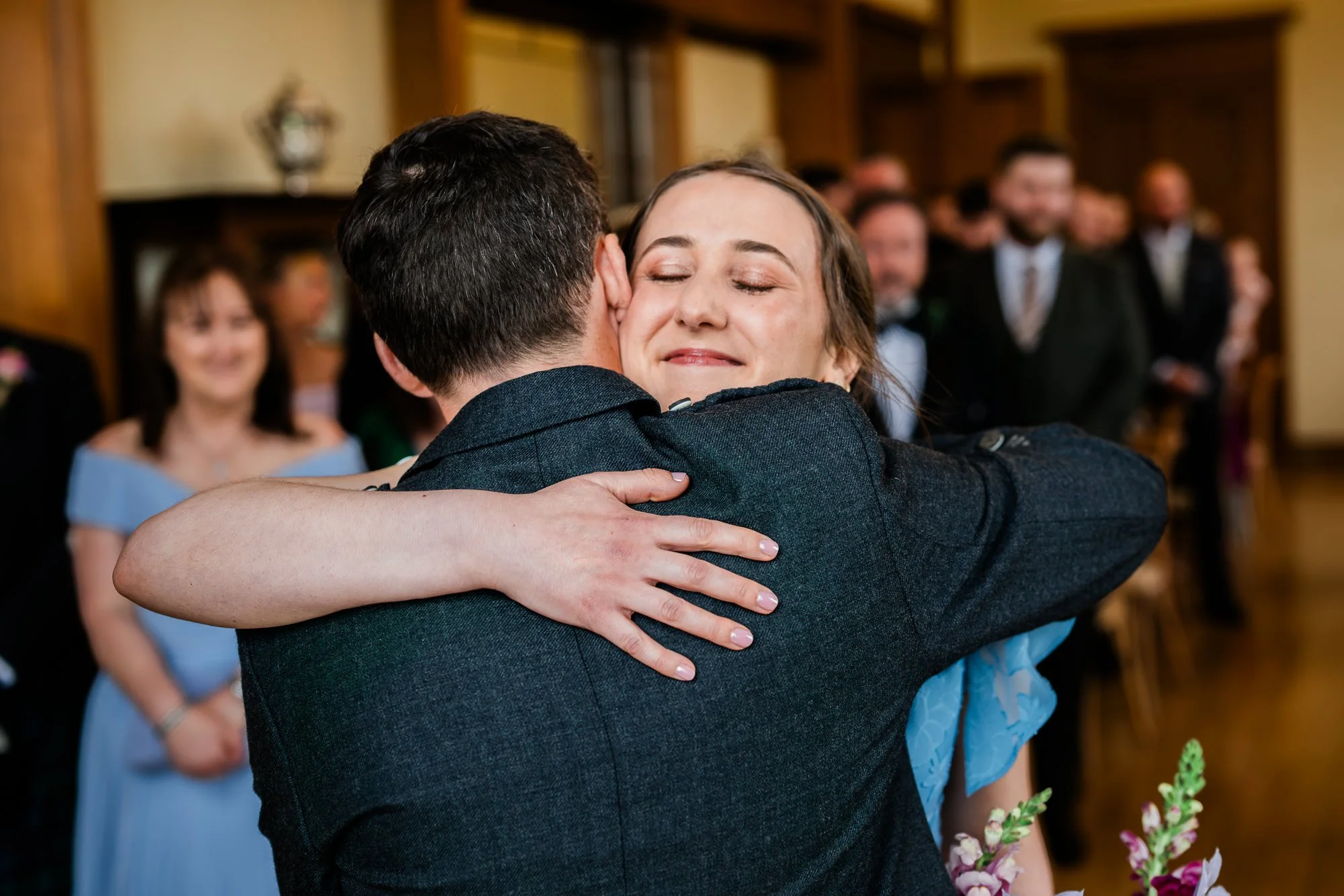 Wedding guests greet each other with a hug before the ceremony.