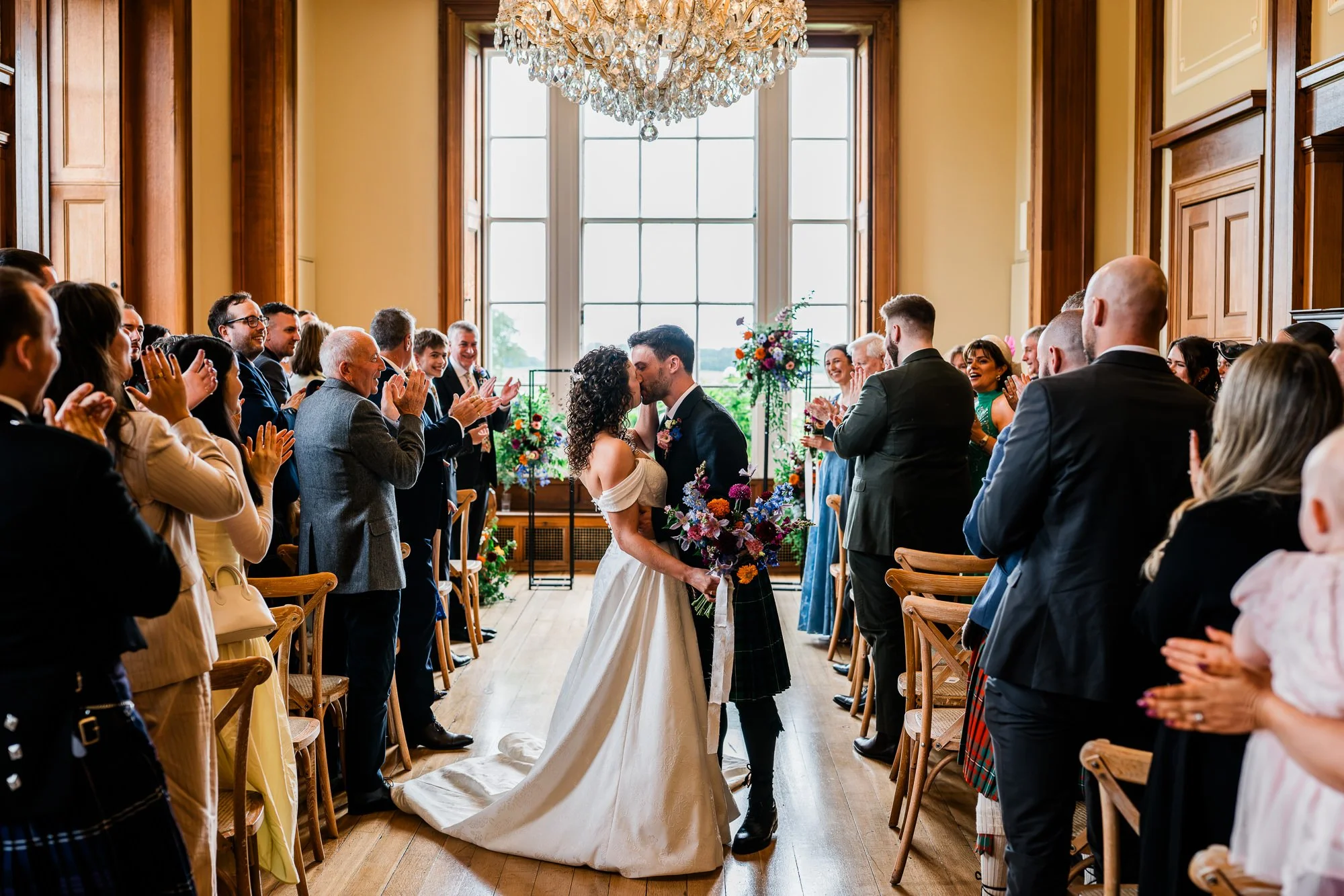 Aimee and Matthew walk back down the aisle as their guests applaud.