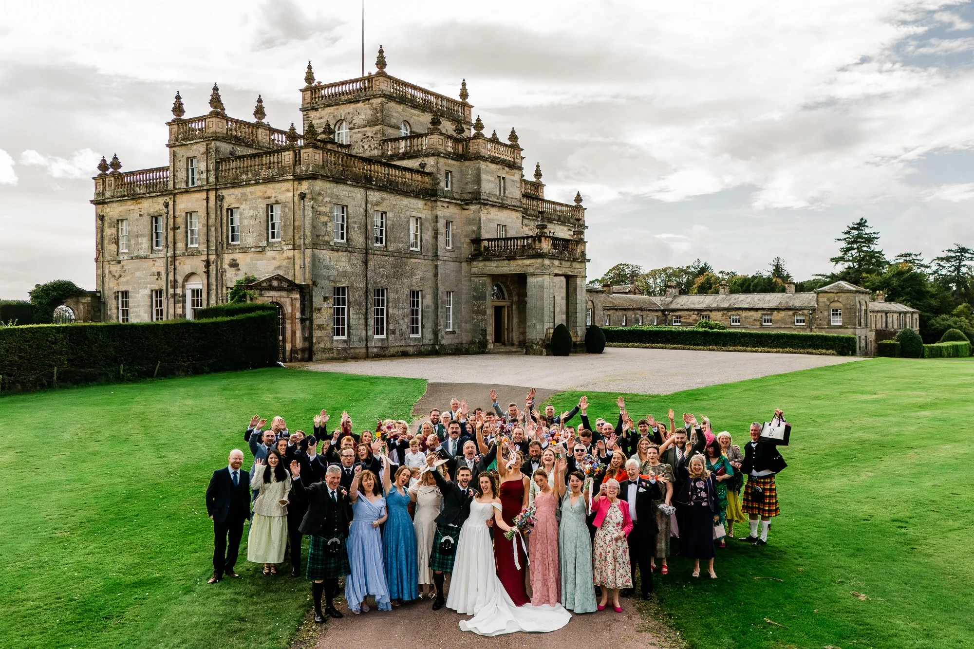 Aimee and Matthew gather with their wedding guests for a group photograph on Kinmount House’s lawn.