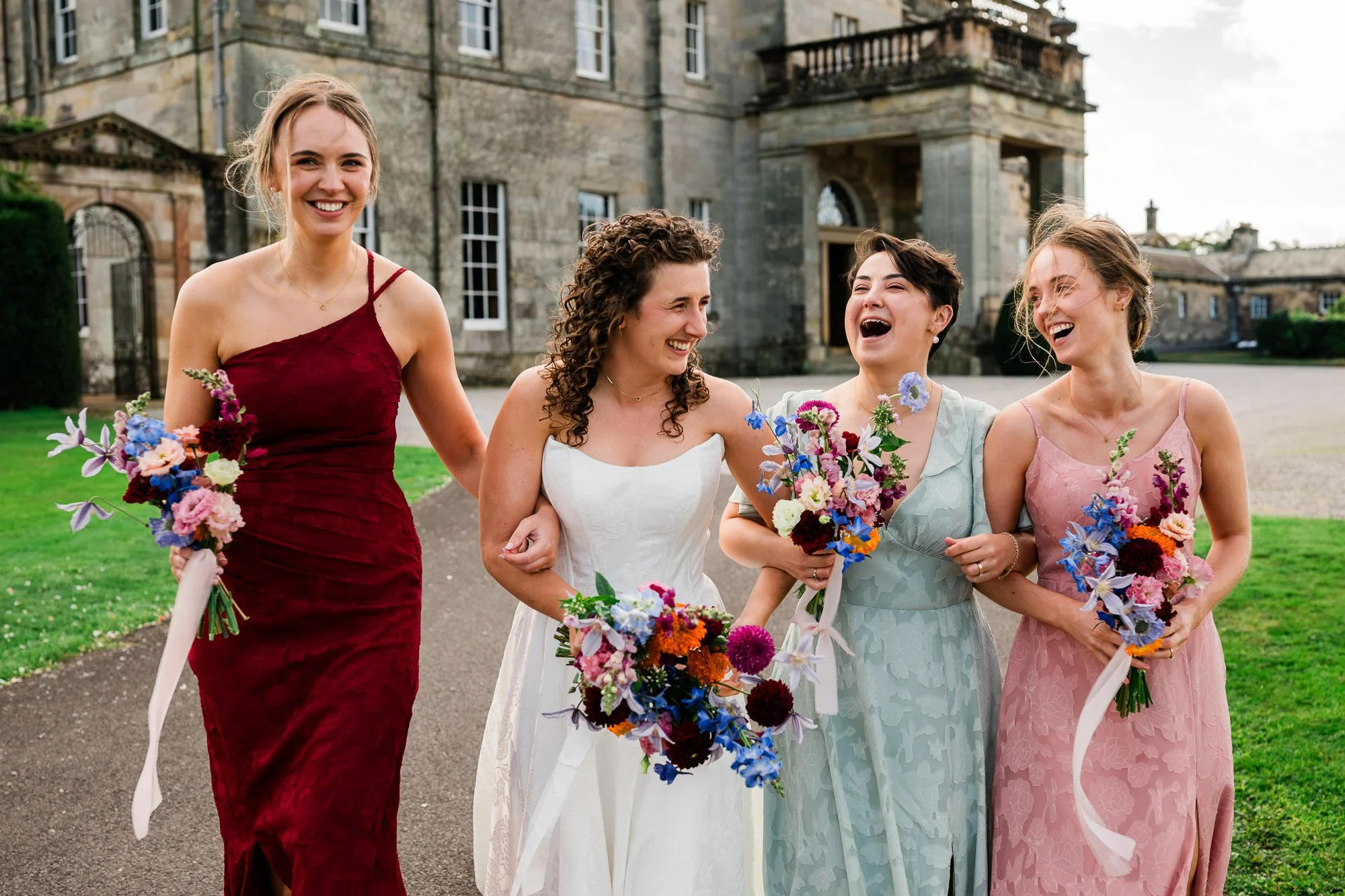 Aimee laughs with her bridesmaids outside Kinmount House.