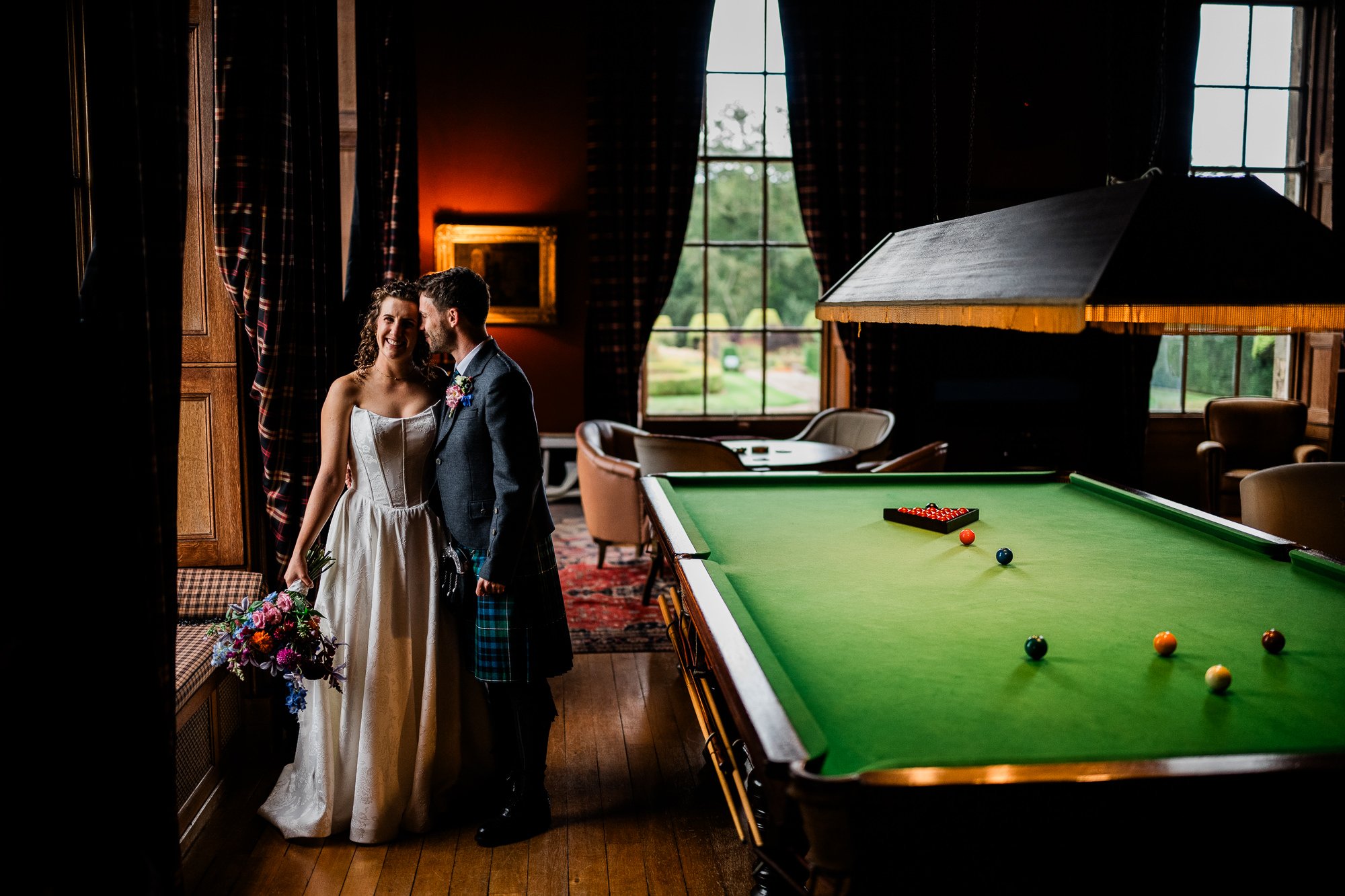 Aimee and Matthew beside the green billiard table inside Kinmount House.