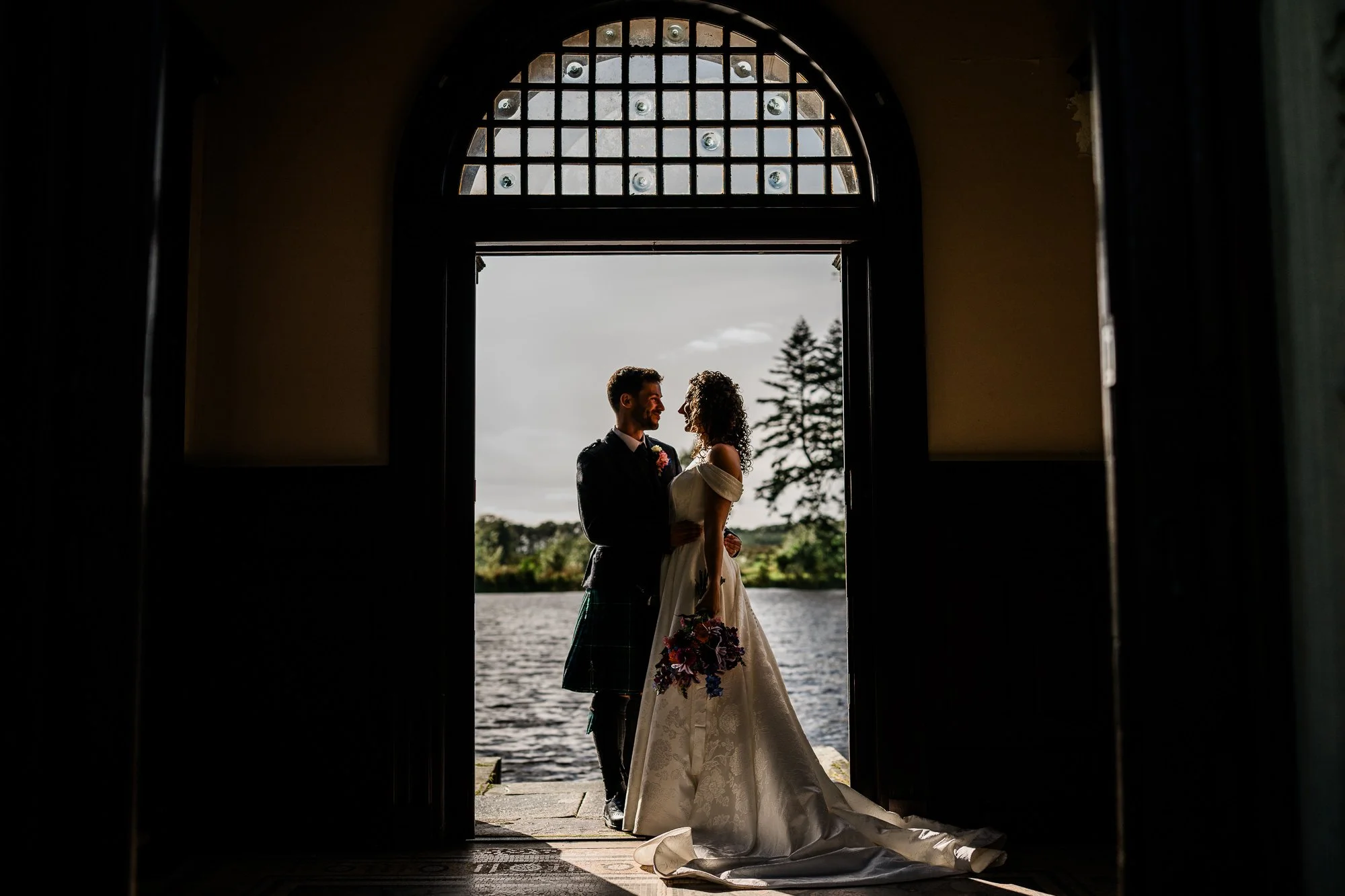 Aimee and Matthew framed by the arched entrance of the Bathing House.