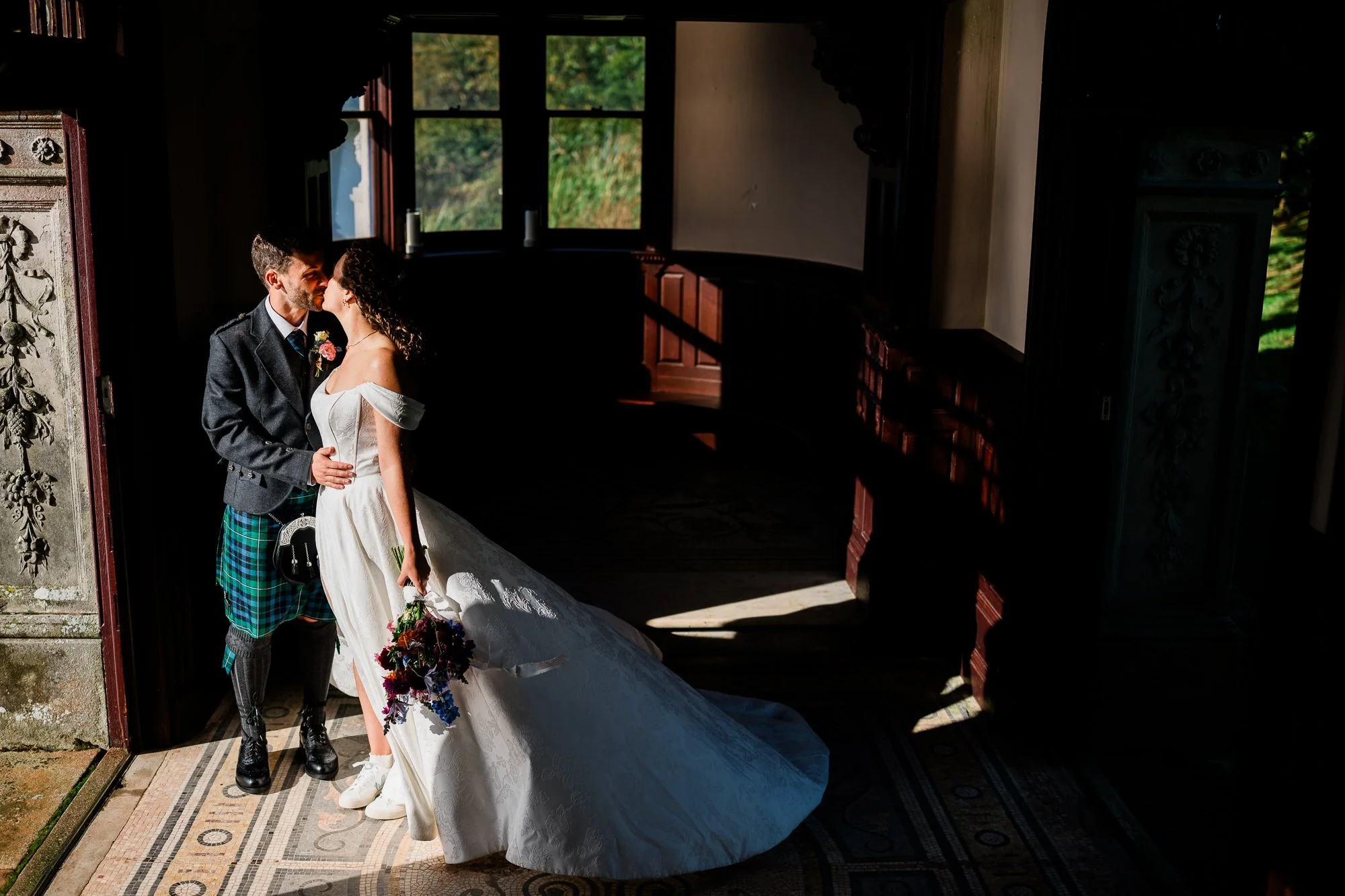 Aimee and Matthew in a sunlit room, with the bride’s train spread across the floor.