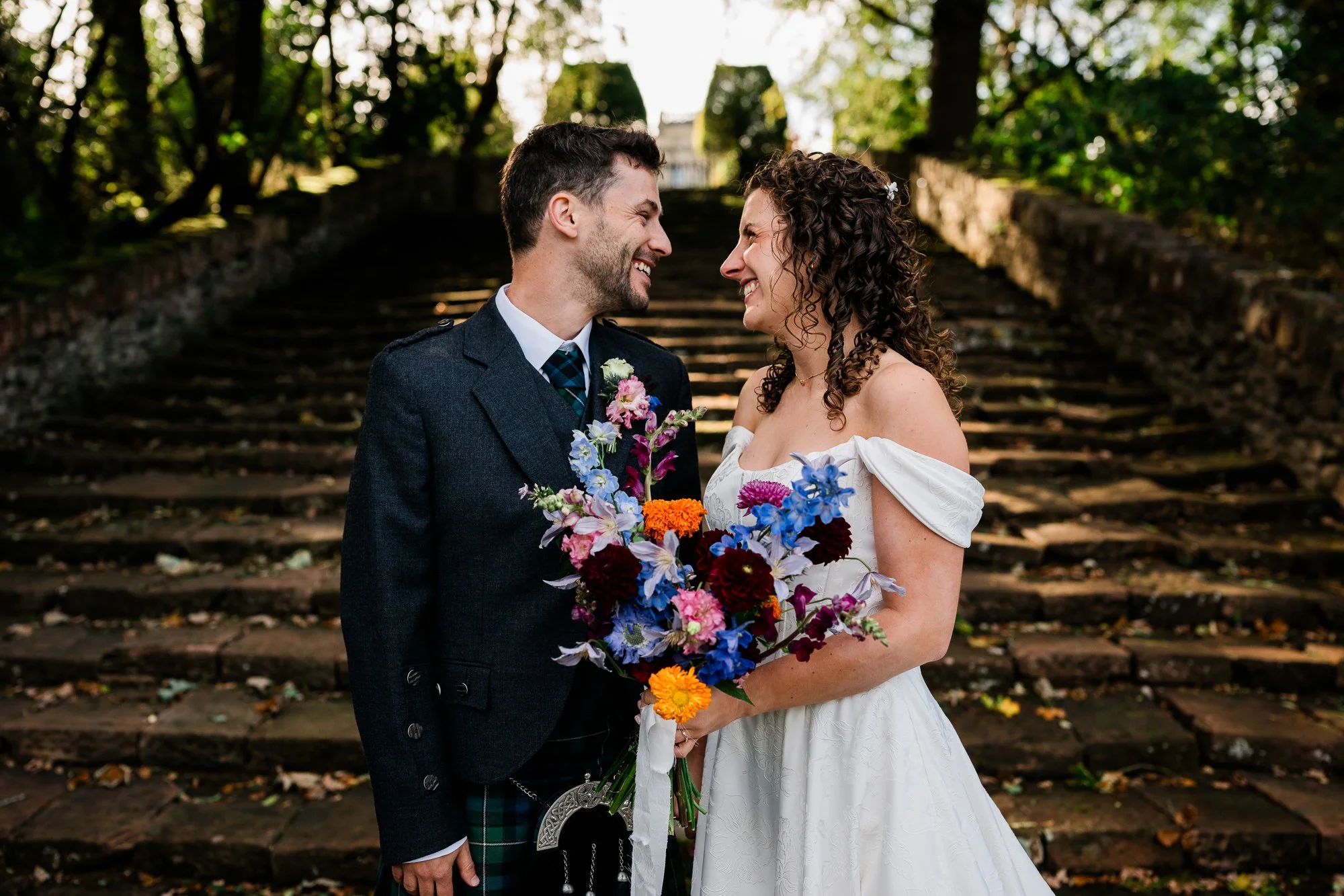 Aimee and Matthew smile at each other on the estate’s stone steps.