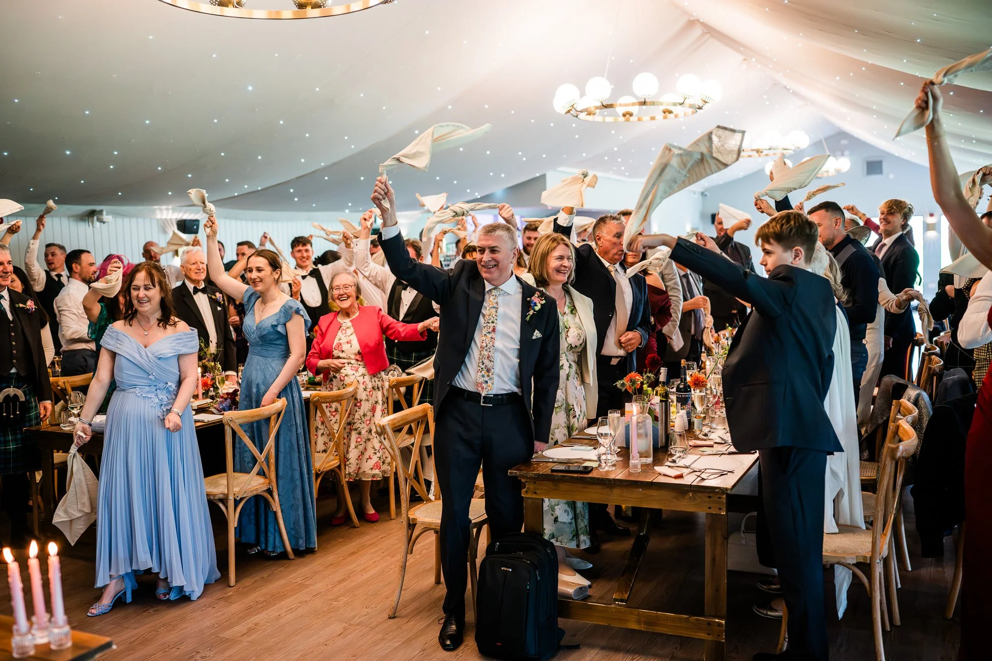 Wedding guests stand and cheer inside the Kinmount Pavilion.
