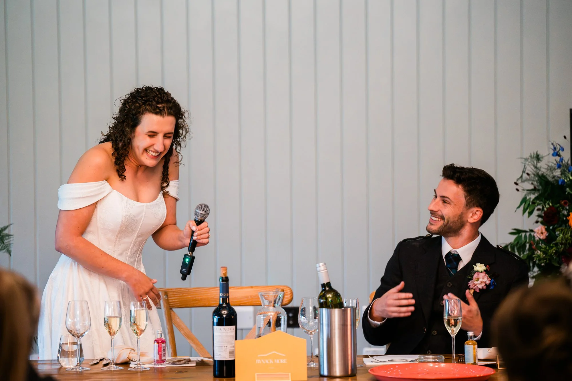 Aimee and Matthew laugh together at the top table during the speeches.