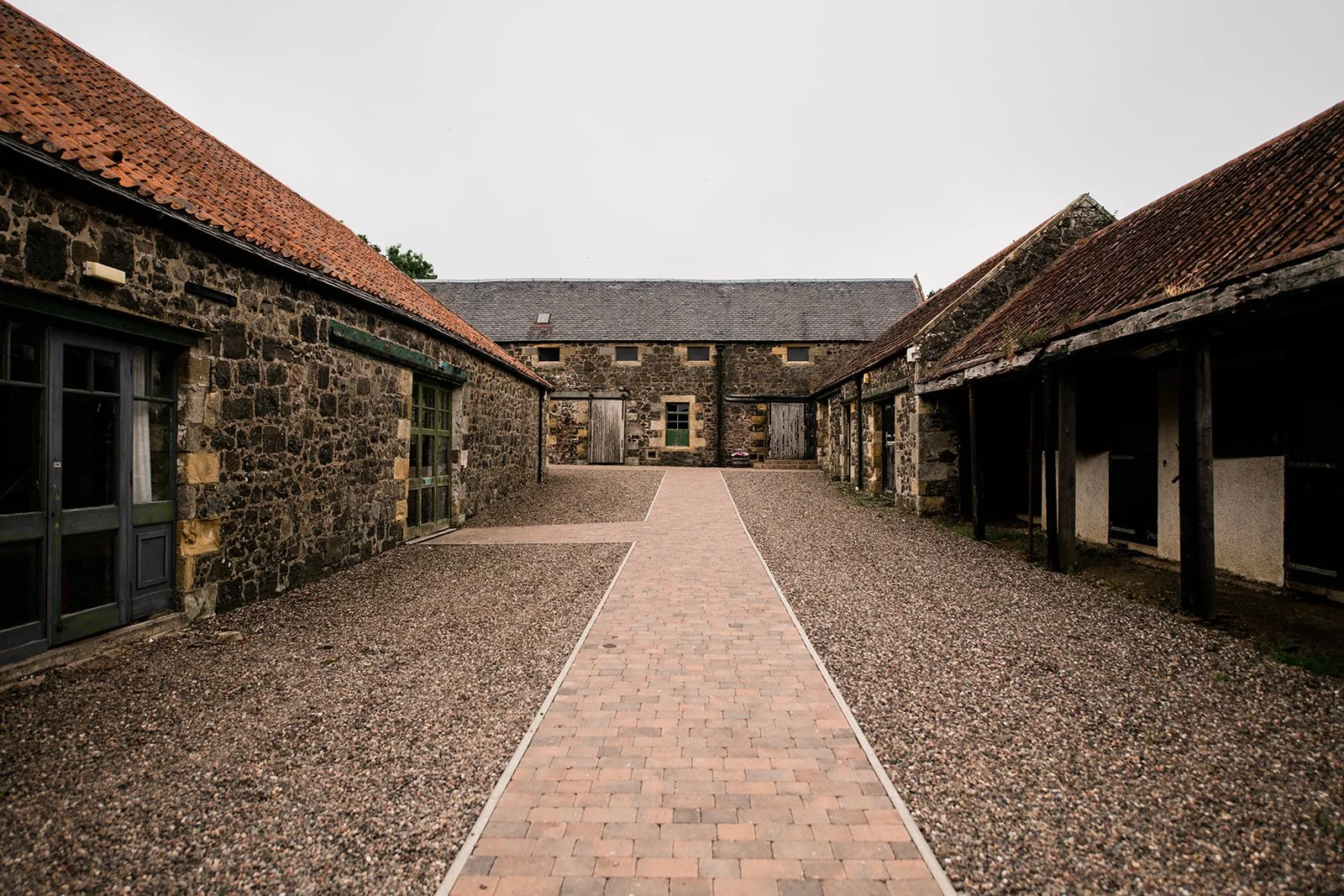 A view along the courtyard between the rustic stone buildings at Pratis Barns.