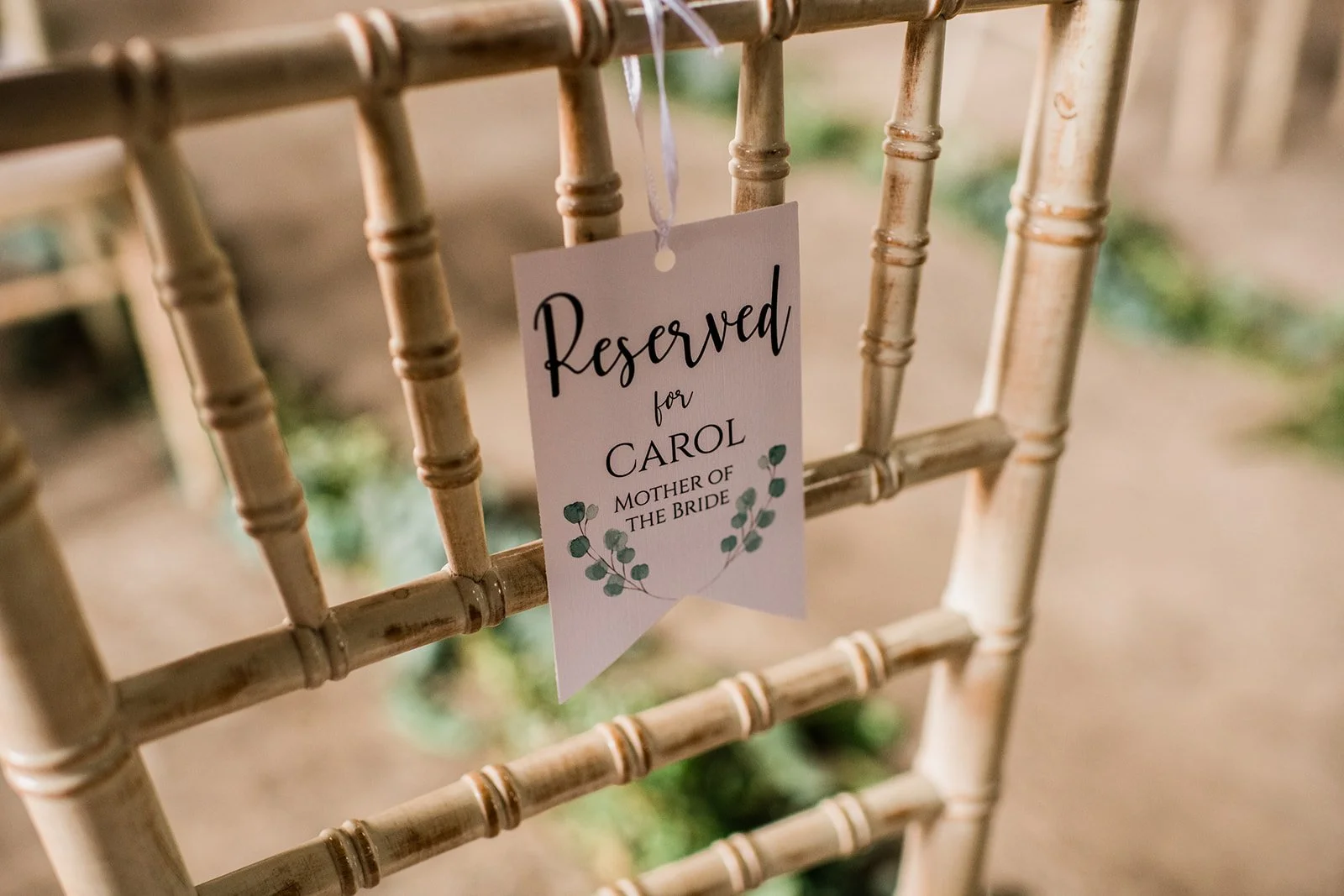 A reserved seat sign hangs from a chair at the wedding ceremony.