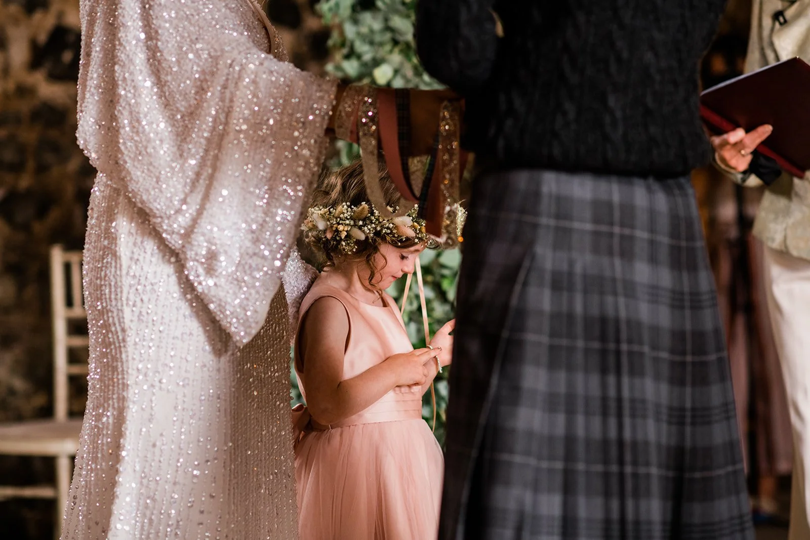 Close-up of the couple holding hands during their ceremony, with the groom wearing a tartan kilt.