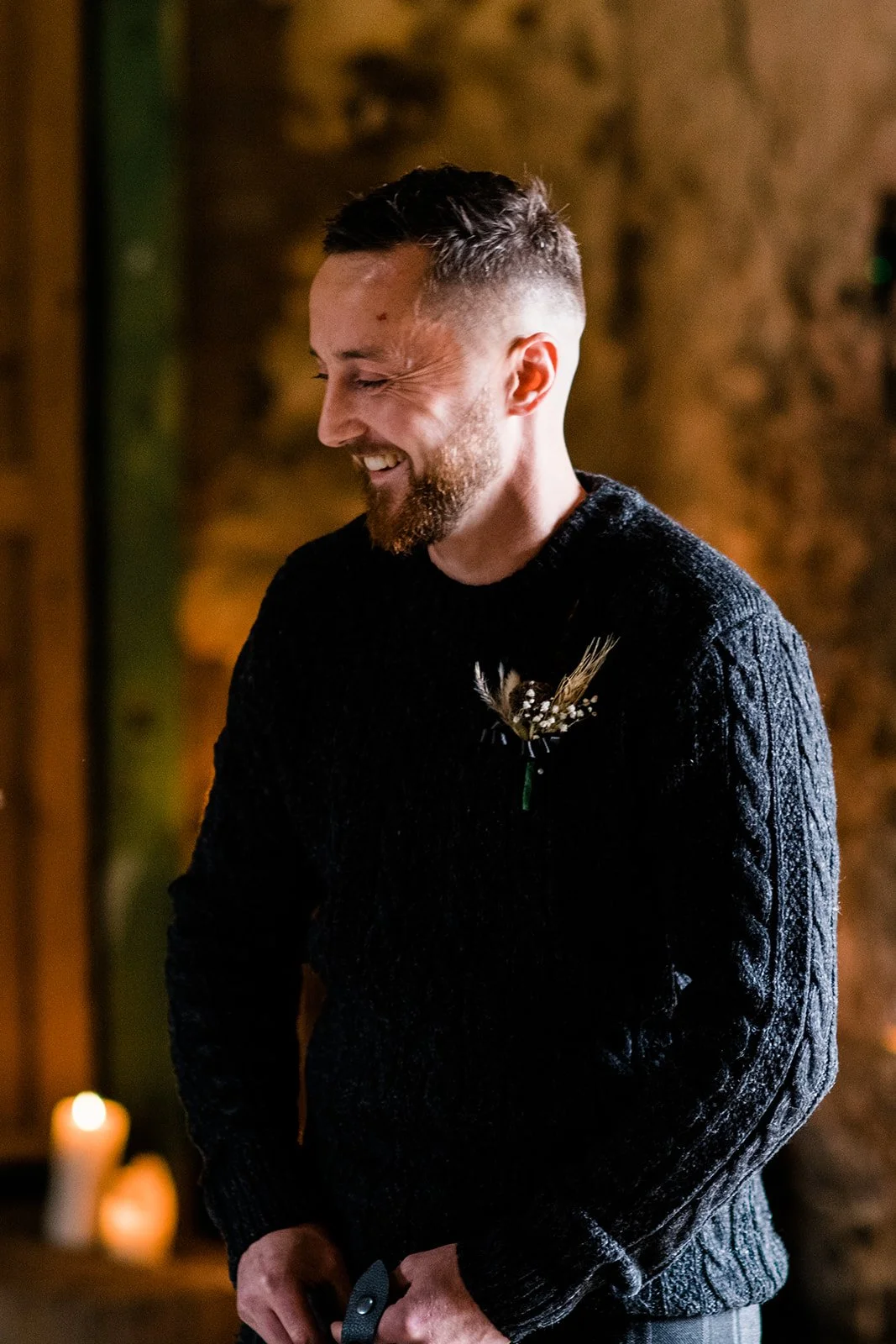 A wedding guest smiles as he watches the ceremony.