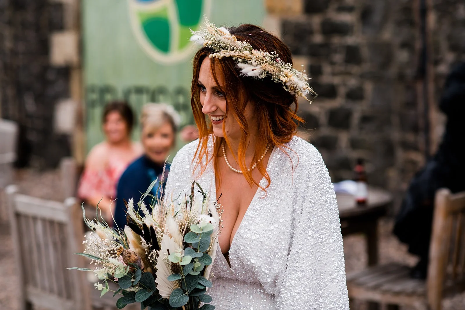 The bride laughs with her guests during the outdoor drinks reception.