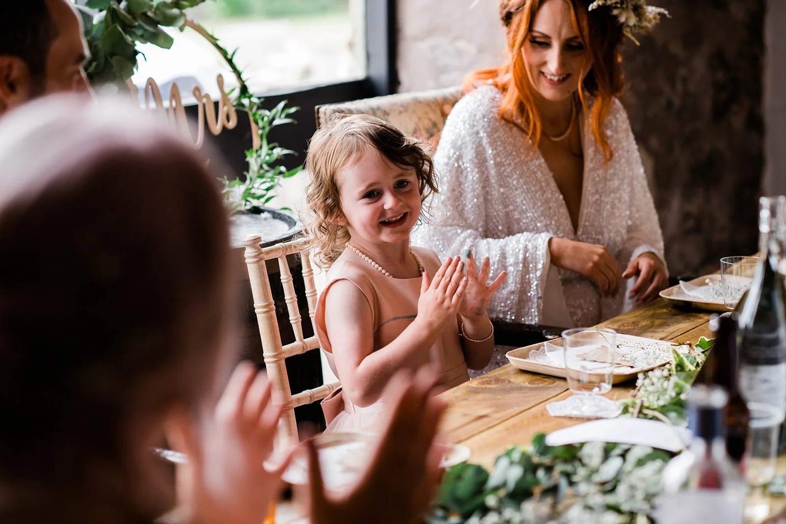 The bride and a young flower girl enjoy a moment together at the reception table.