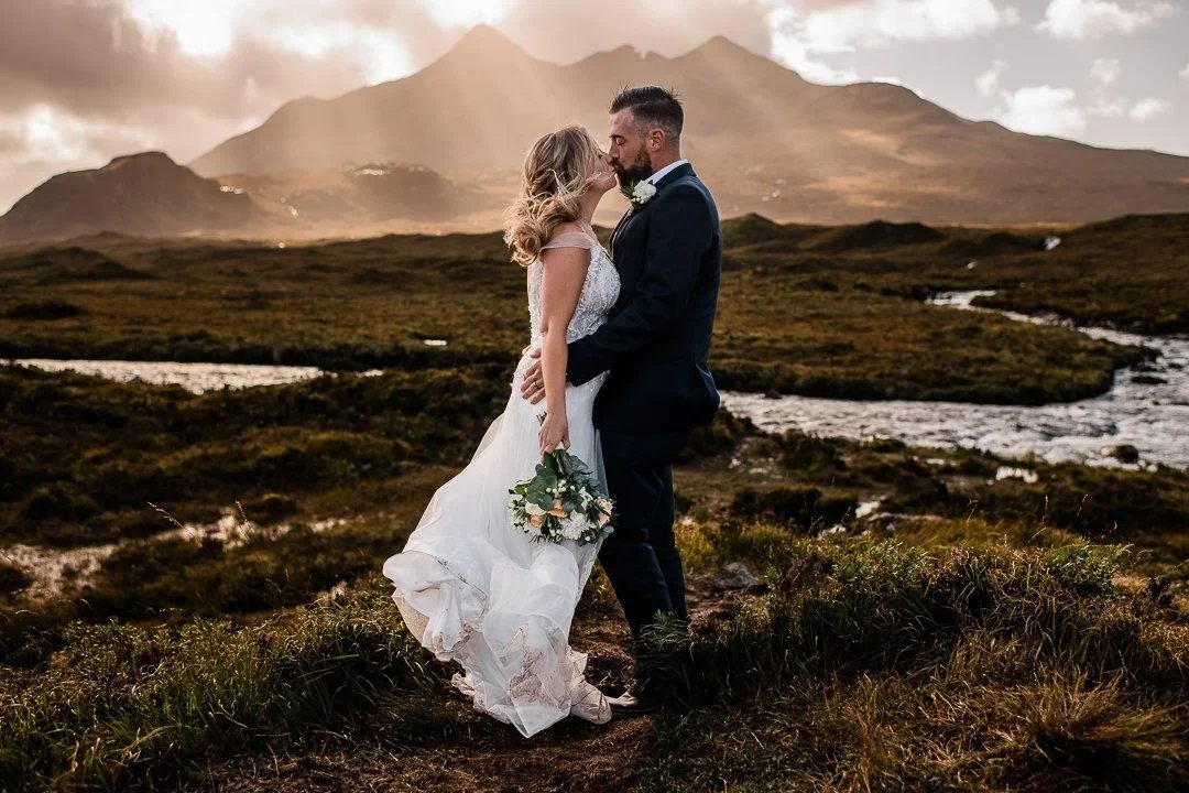 Isle of Skye elopement - Bride and groom kissing in front of a mountain