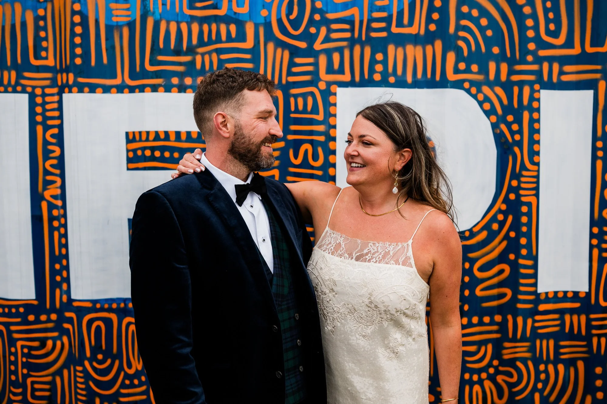 Bride and Groom standing in front of graffiti wall in Edinburgh