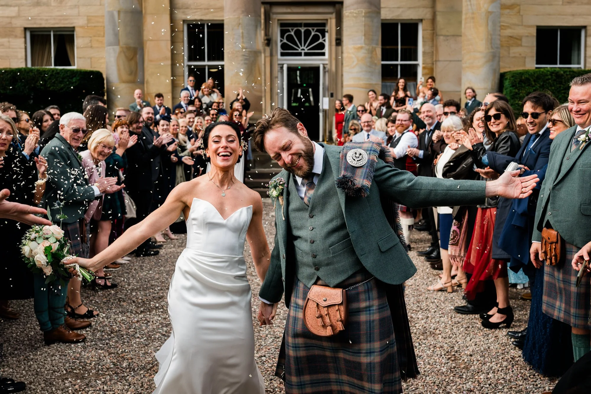 Bride and groom running through confetti at Balbirnie House