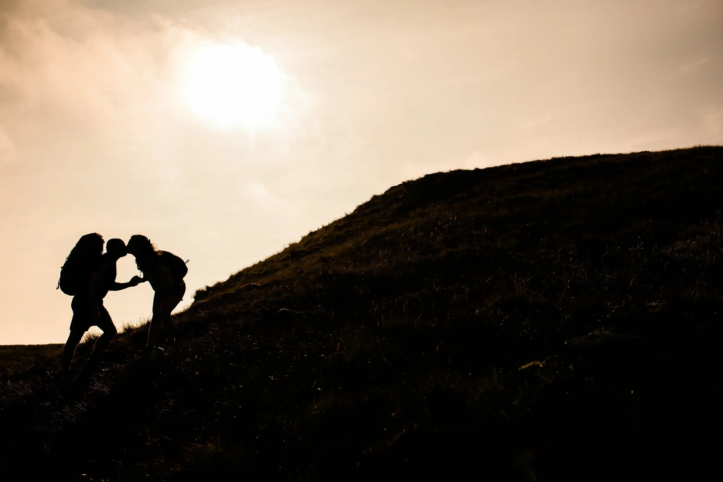 Bride and groom hiking up a hill to their elopement ceremony