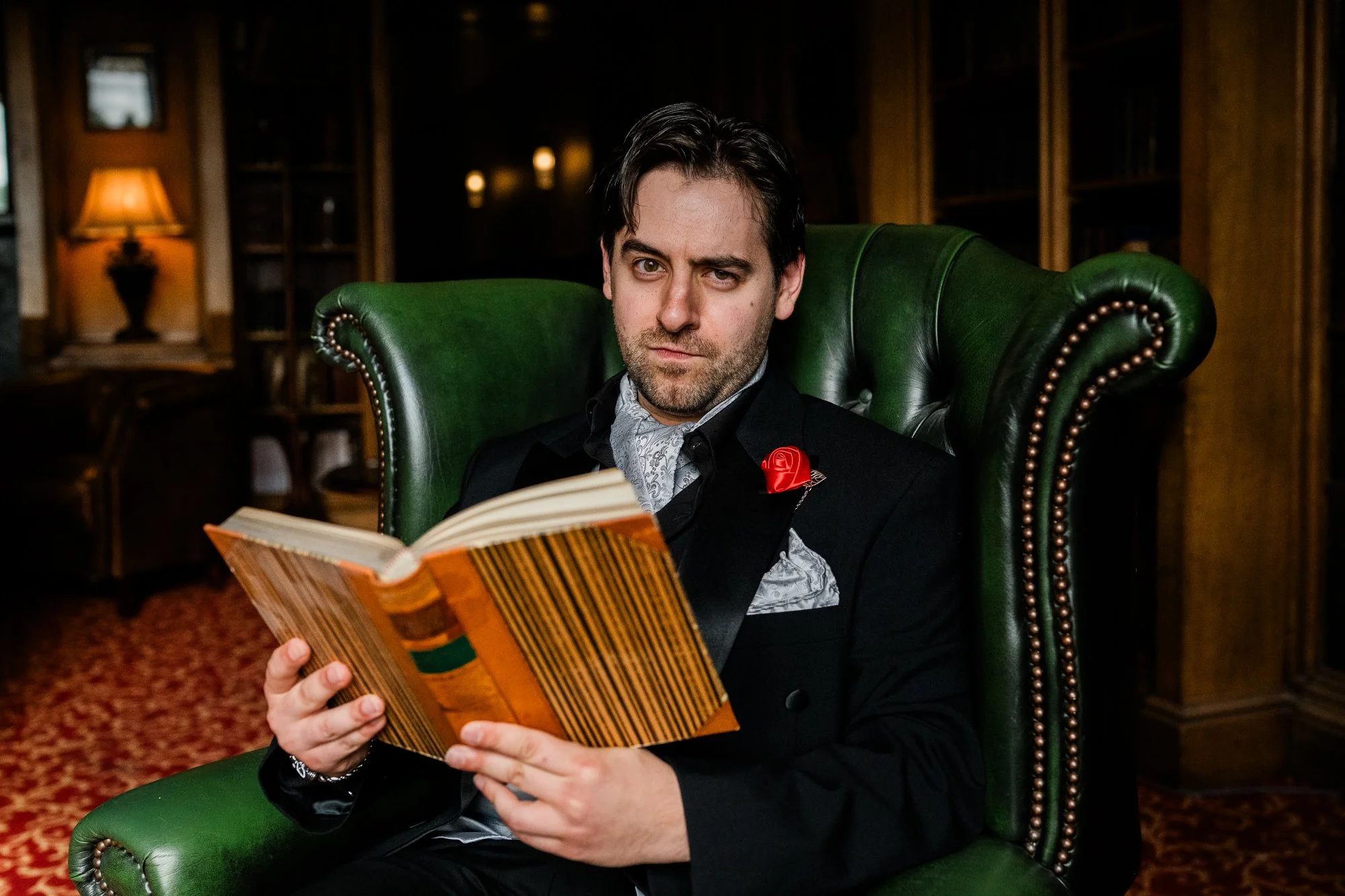 Funny picture of groom reading a book in Dalhousie Castle library