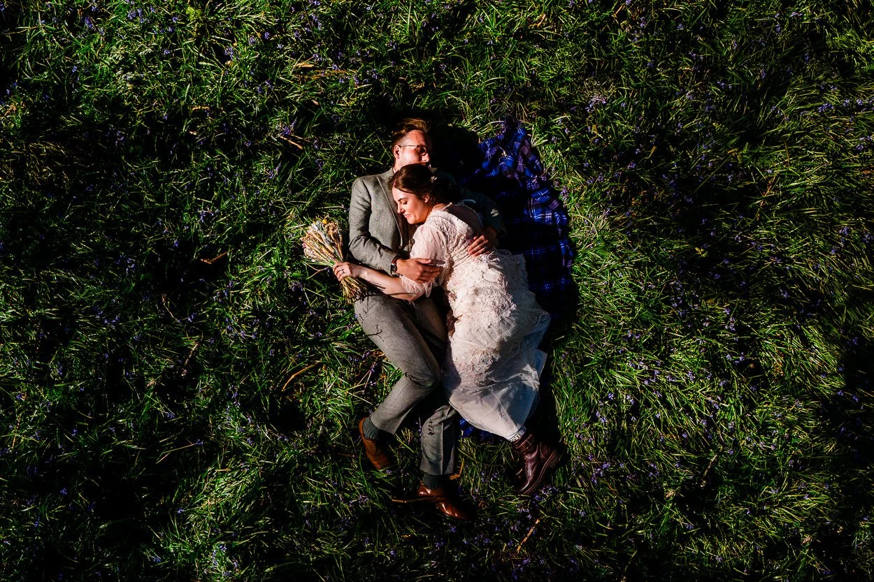 drone-photograph-of-wedding-couple-lying-romantically-amongst-bluebells
