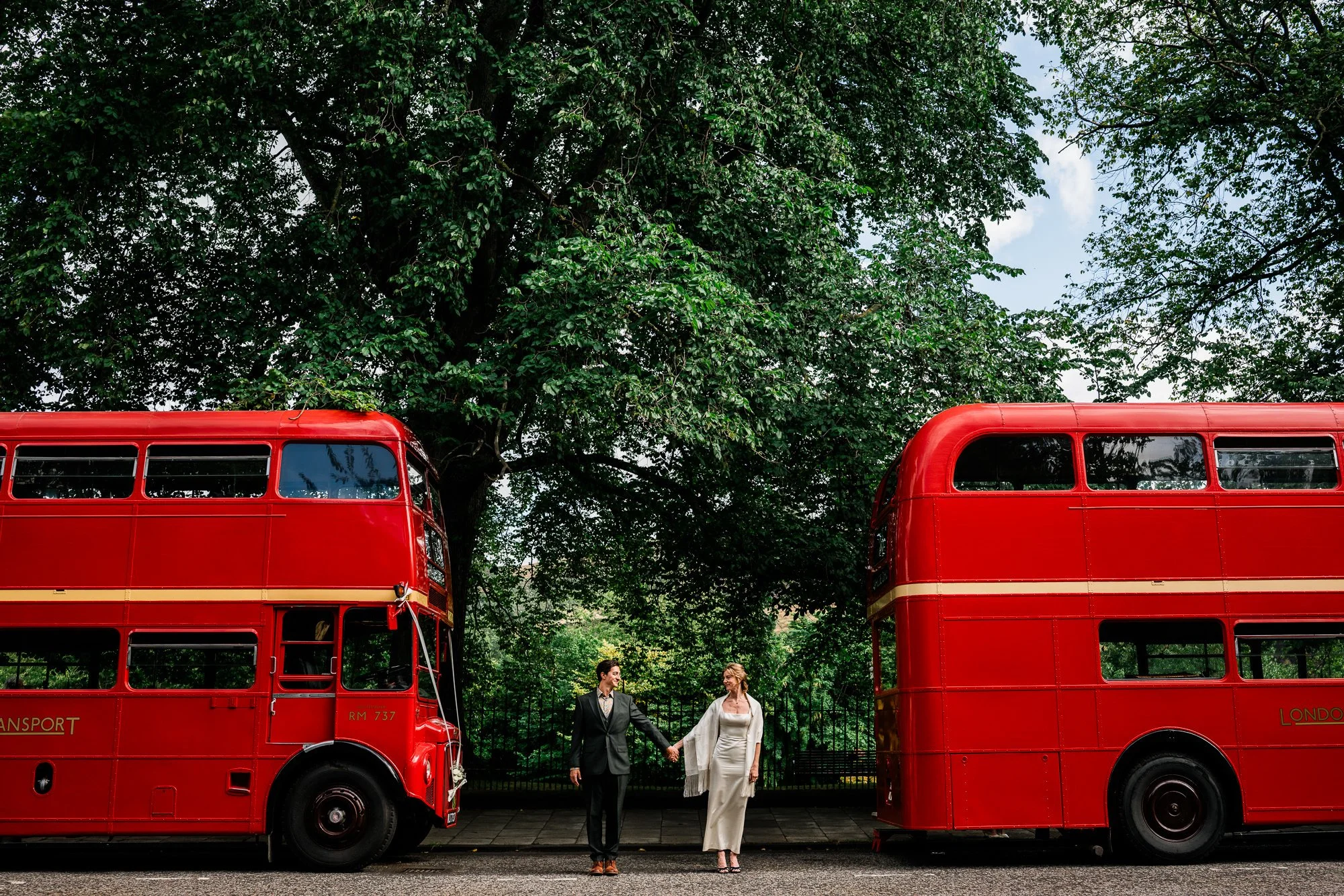 Bride and Groom between two red vintage buses Edinburgh