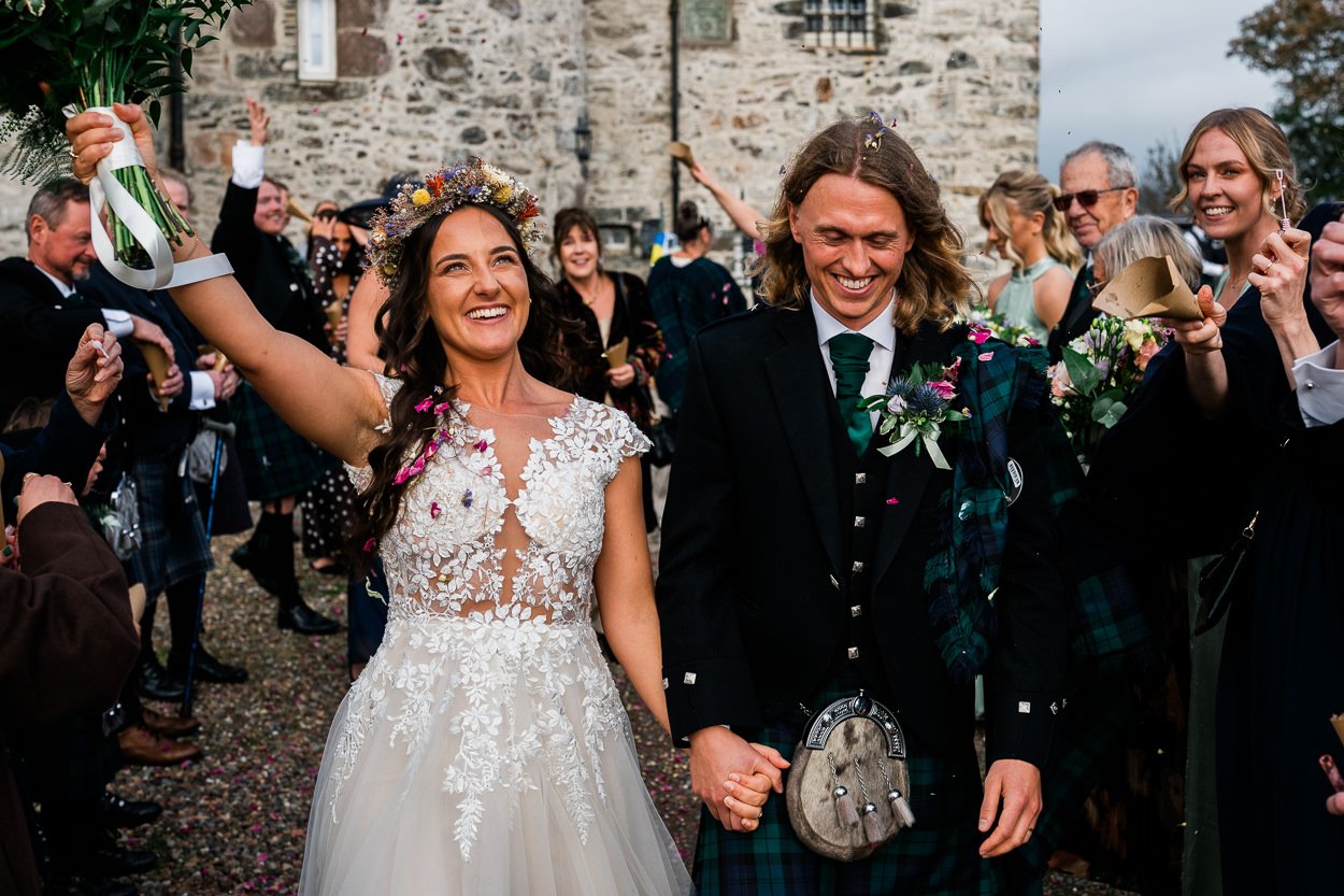 Bride-and-groom-running-through-confetti-with-huge-smiles