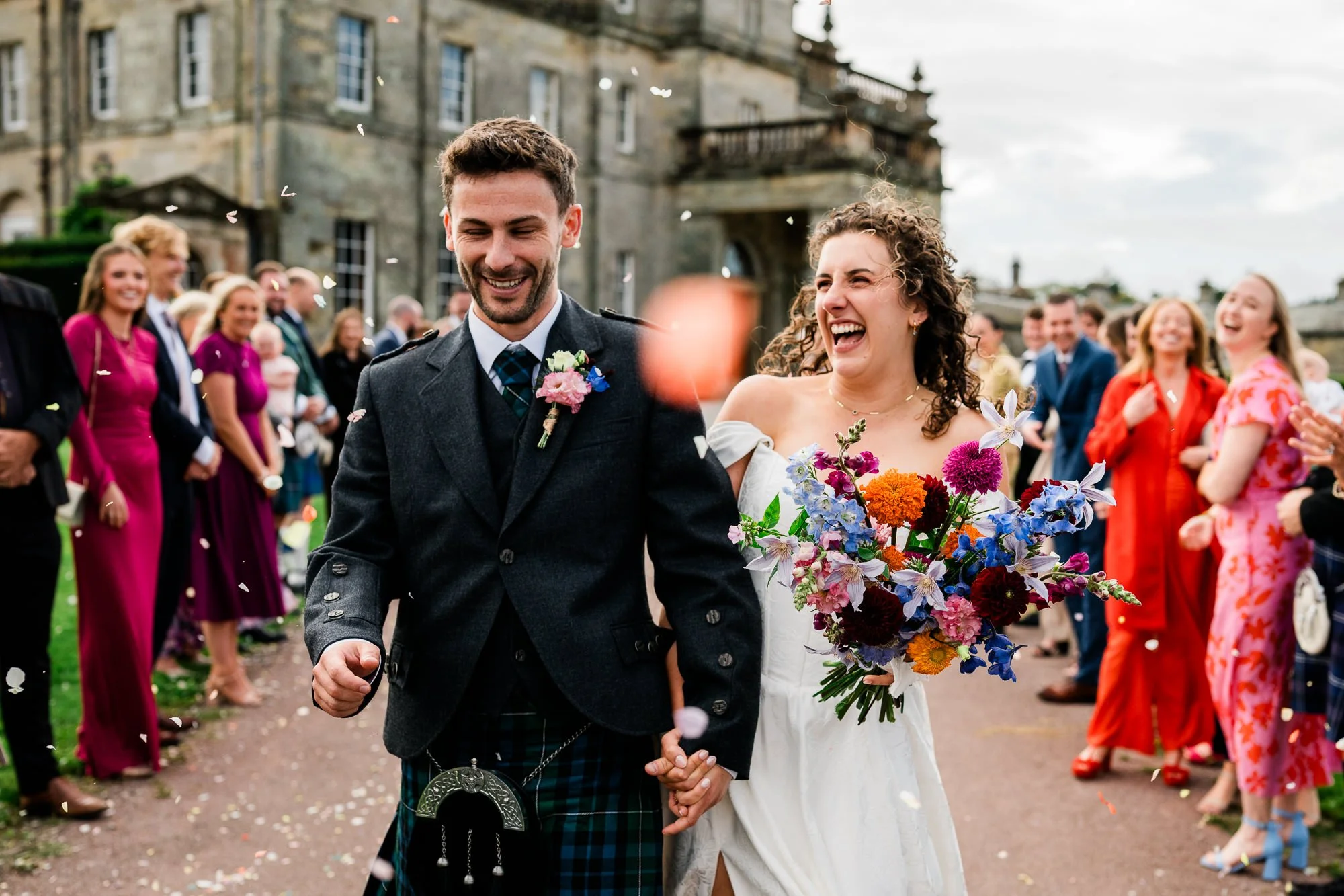 Bride and groom running through confetti at Kinmount House