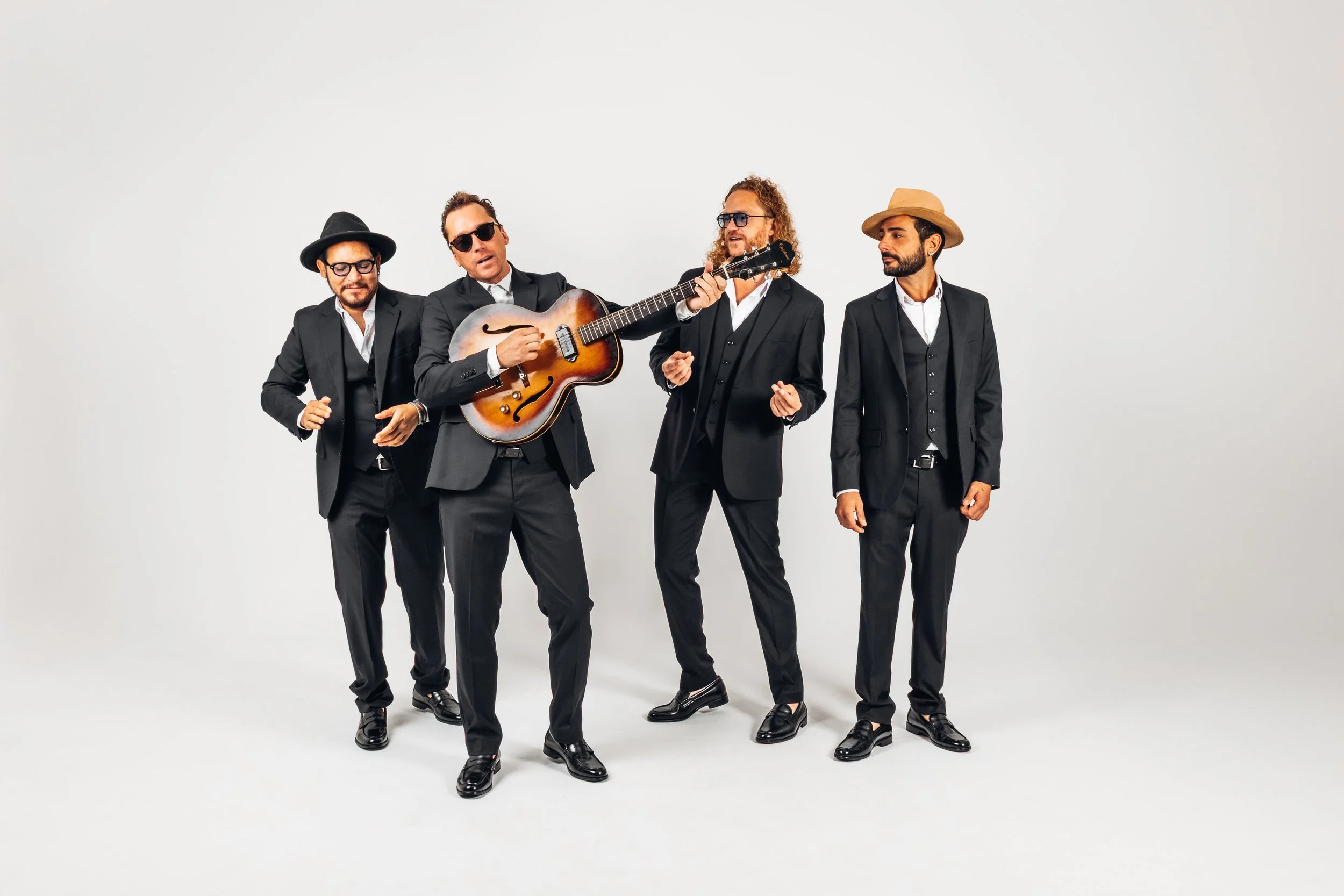 The Jesterz in an elegant group portrait wearing suits, a vocal-driven roaming band from the French Riviera known for live music at weddings and private events.