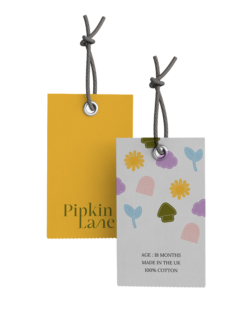 Two clothing tags hanging from gray strings, one yellow with the text "Pipkin Lane" and one with colorful illustrations and text indicating age, origin, and material.