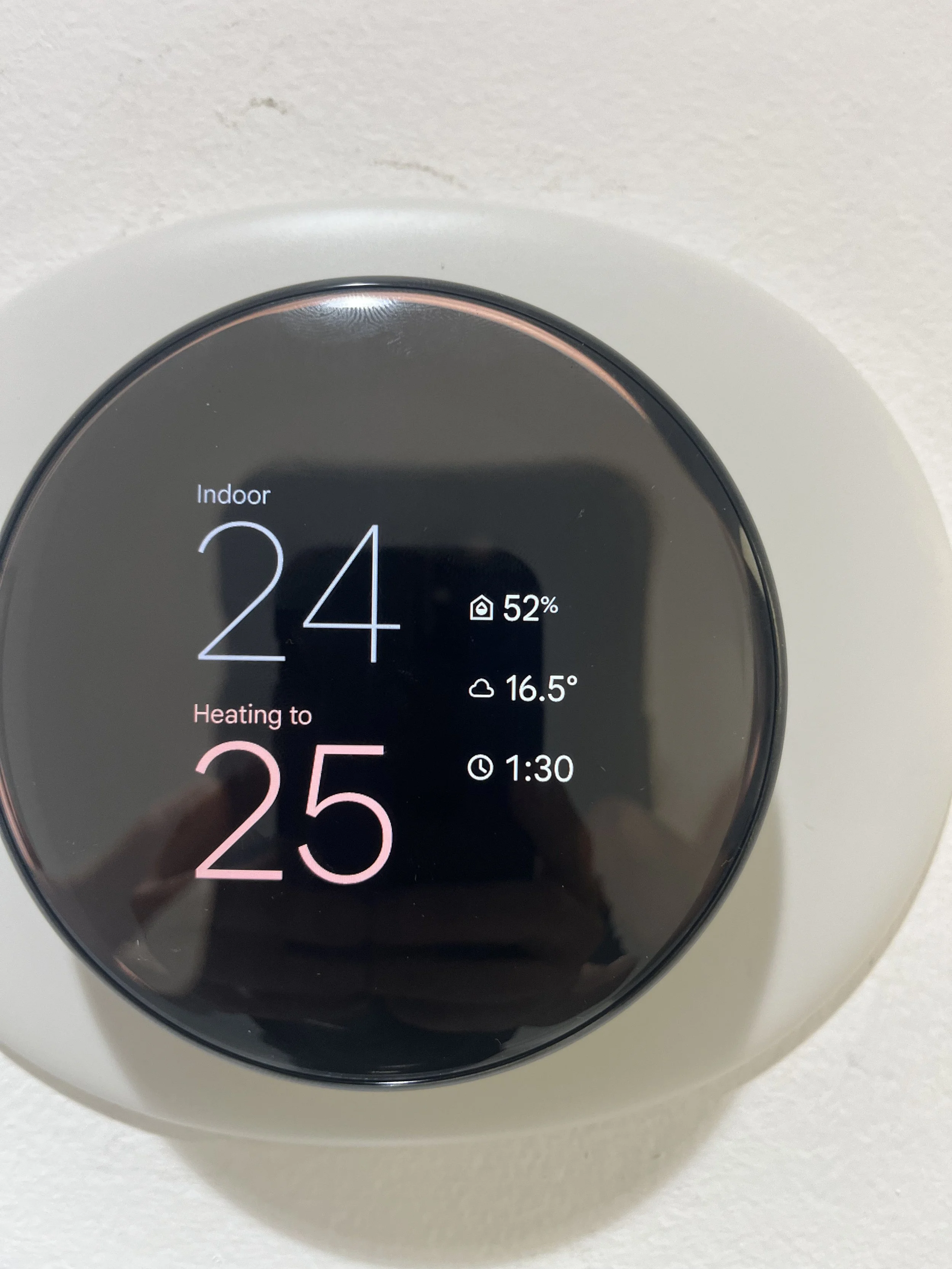 Smart thermostat displaying indoor temperature of 24 degrees Celsius, heating to 25 degrees, battery at 52%, weather forecast showing 16.5 degrees Celsius, and timer set for 1 hour 30 minutes.