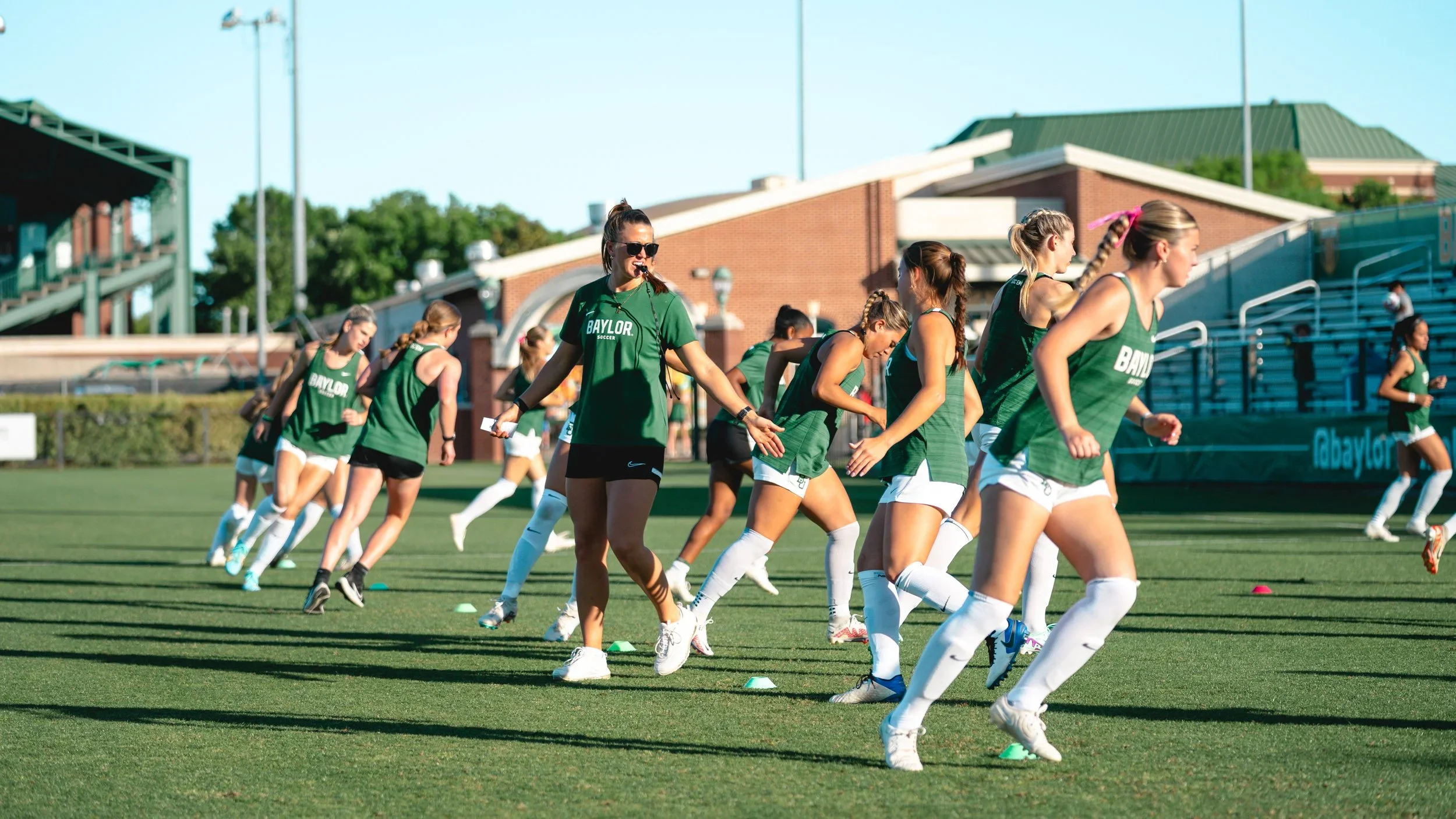 Malorie coaching a team of soccer players.