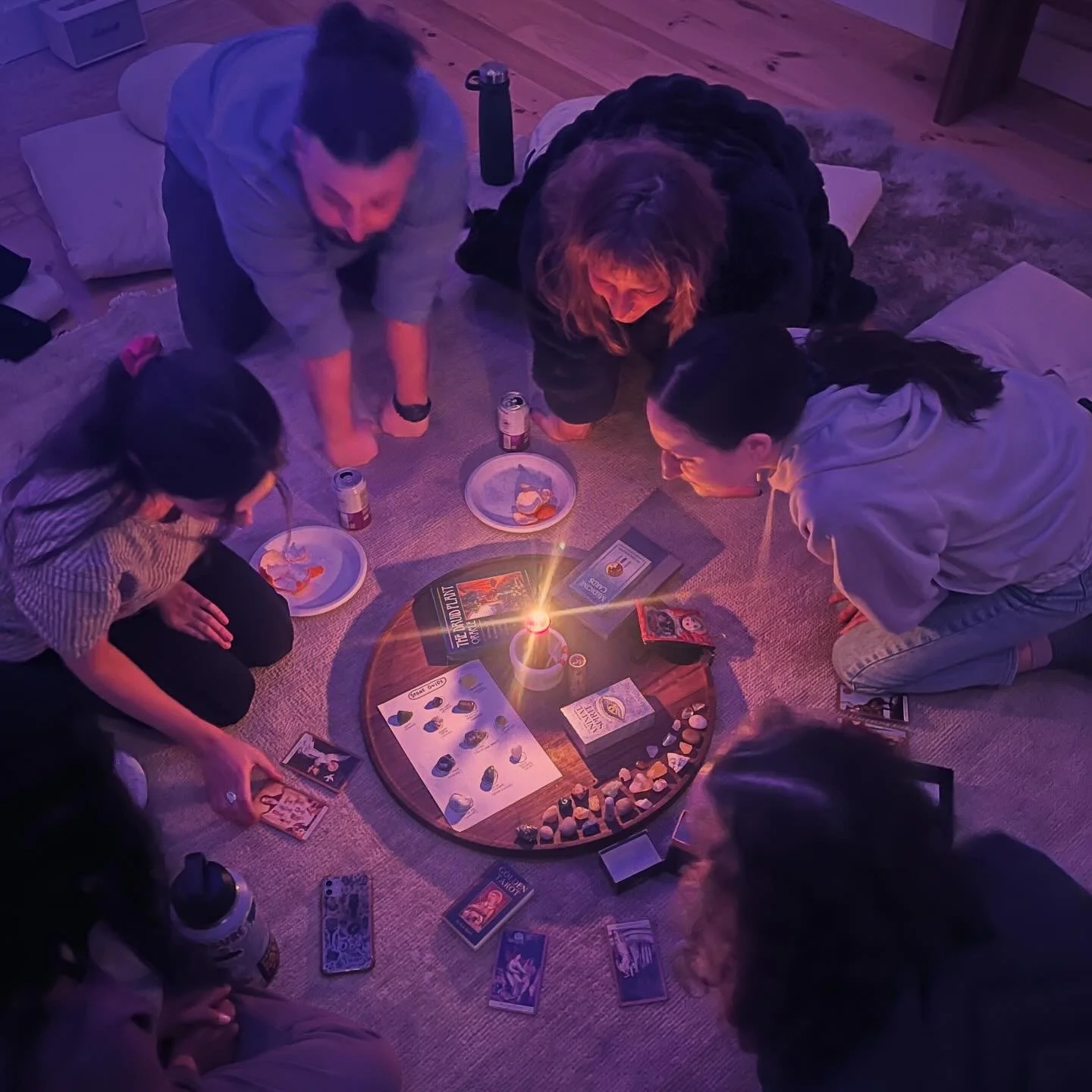 Group of people looking at tarot cards around a circular altar