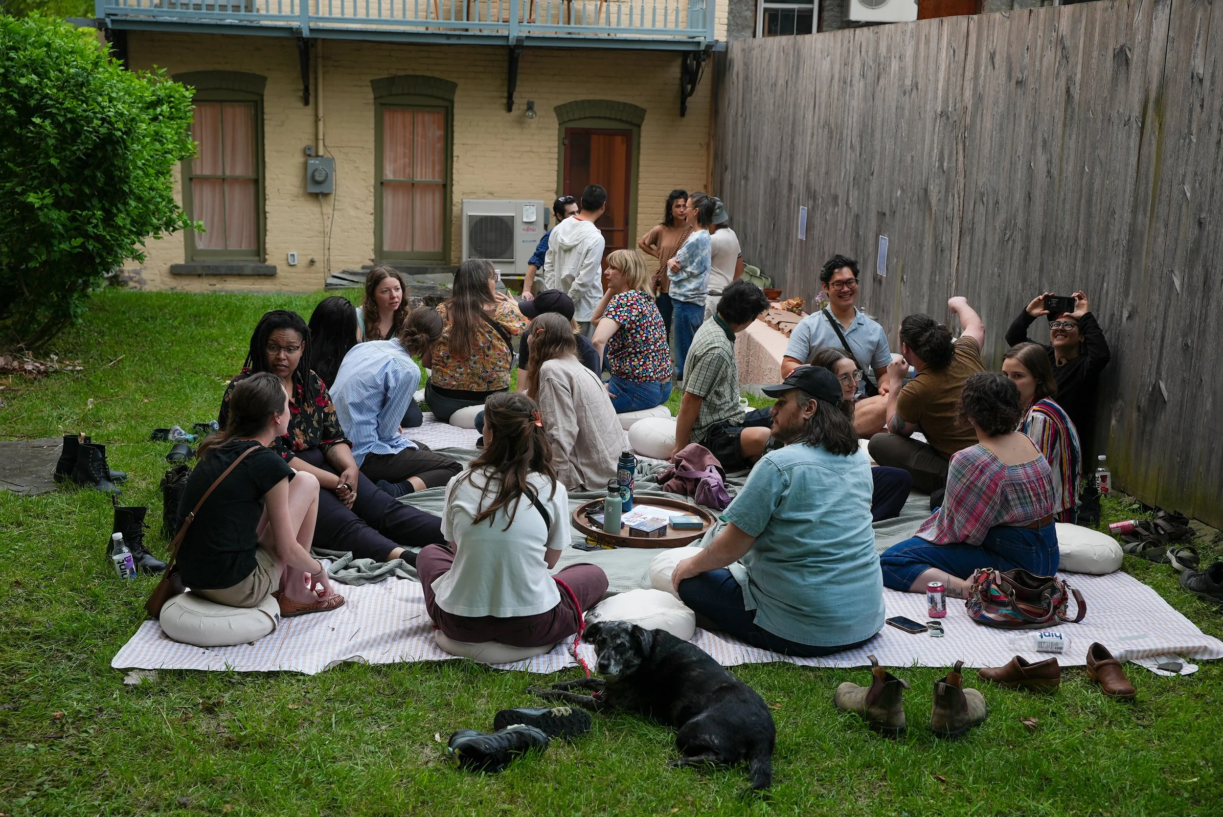 Crowd of people on a blanket outside in a yard