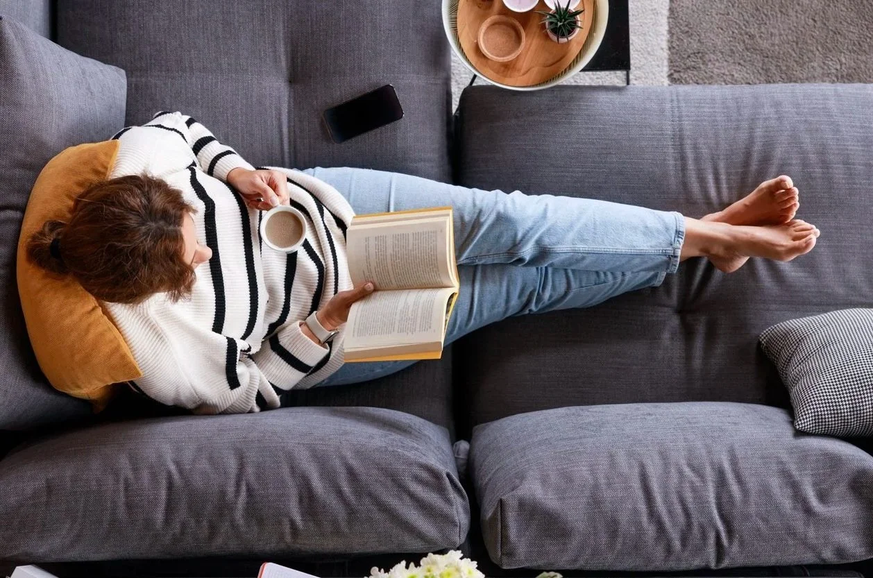 Woman reading quietly on a couch, reflecting the inner work that accompanies EMDR therapy for complex PTSD and attachment trauma