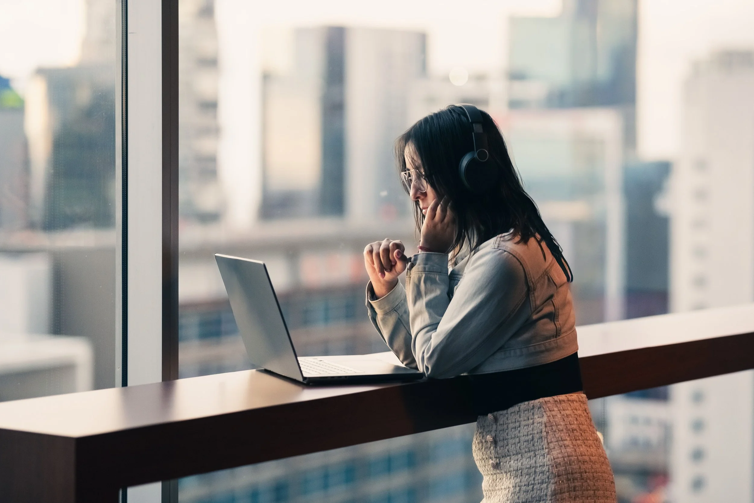 Professional woman at a laptop with headphones, representing an online EMDR therapy session with Olivia Lavelle, LCSW in California