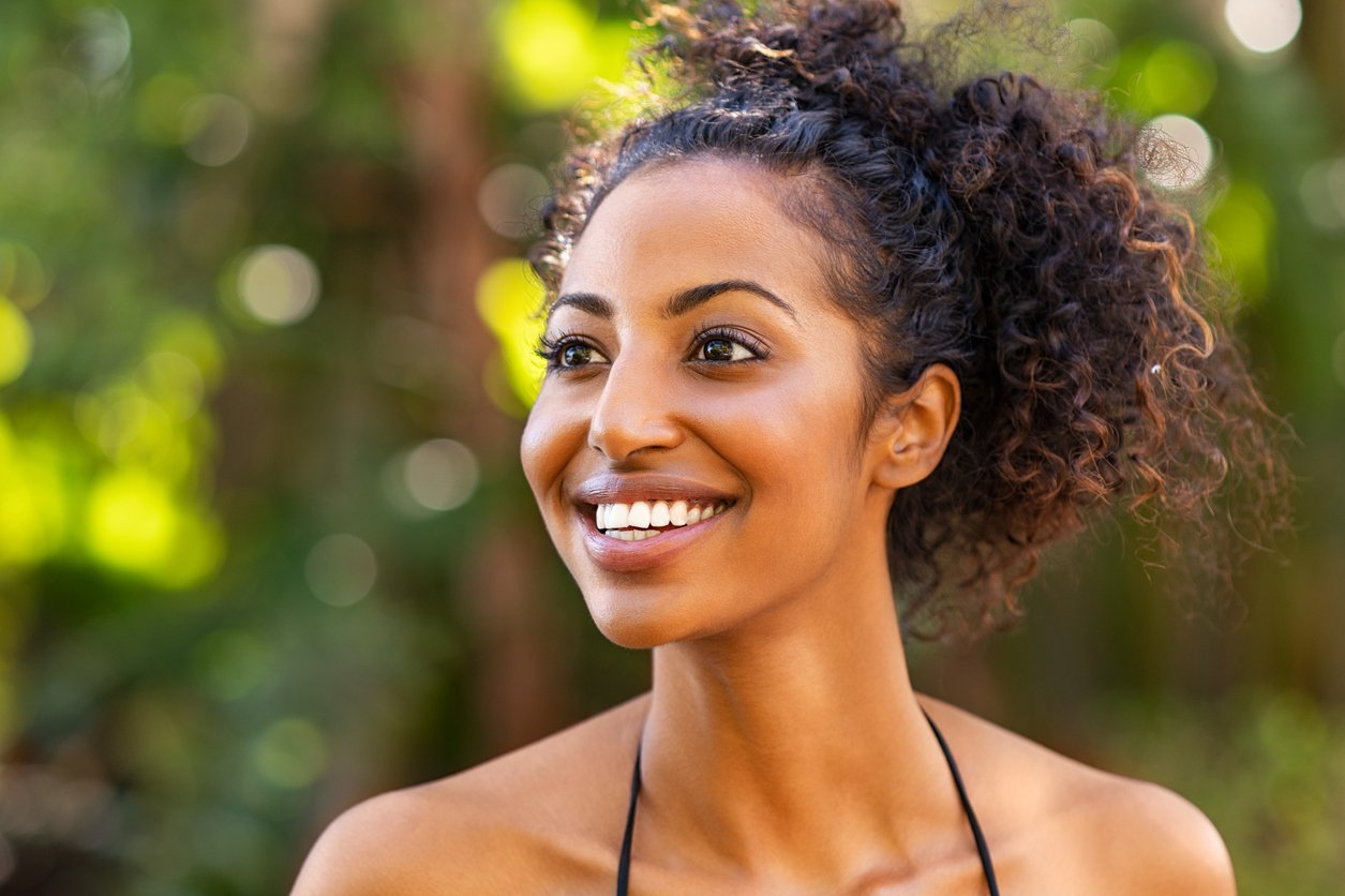 Woman smiling in soft outdoor light, online EMDR therapy for Santa Monica women.