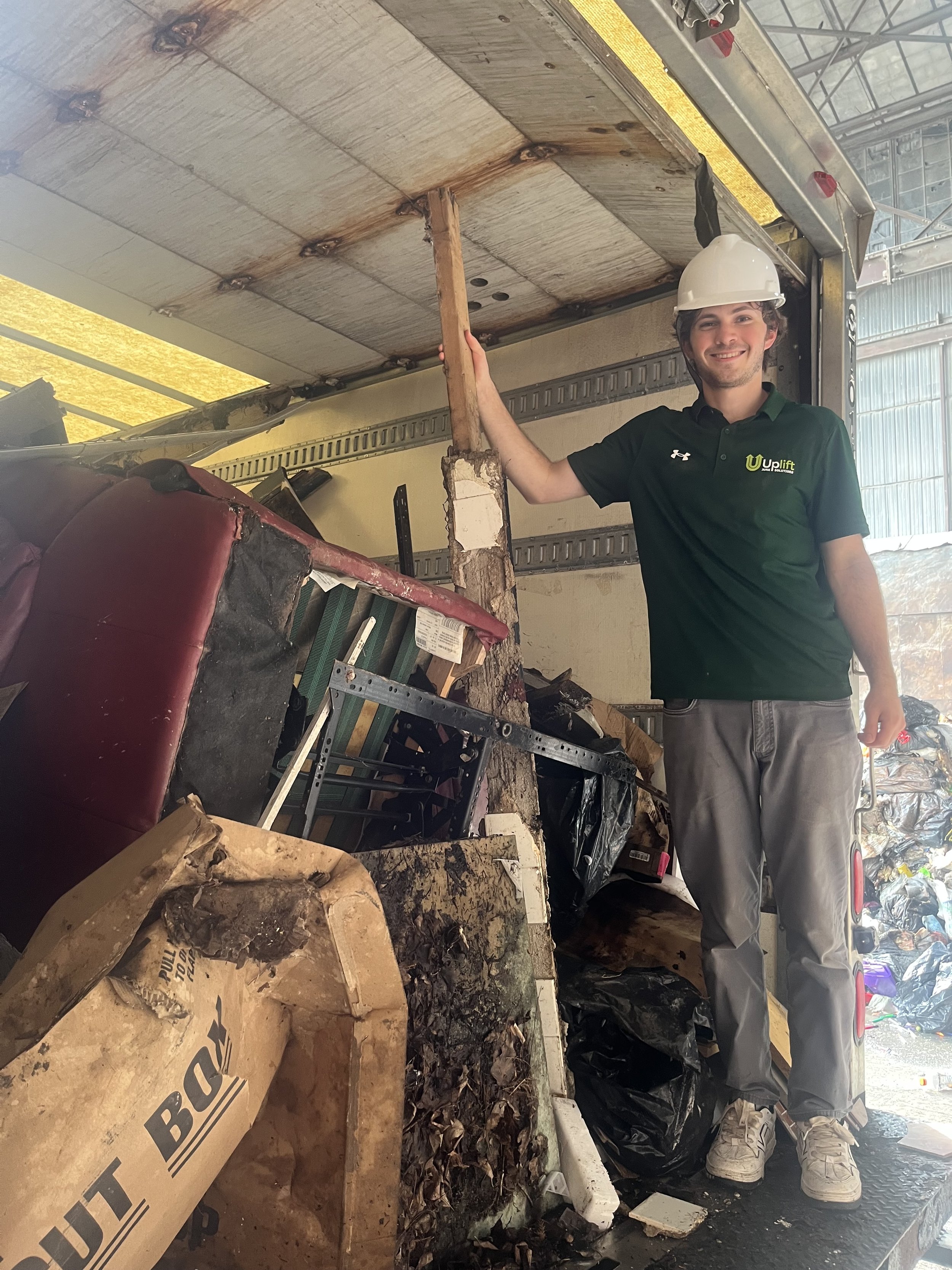 Two professional junk haulers from UpLift Junk Solutions removing old furniture from a Northeast Philadelphia home