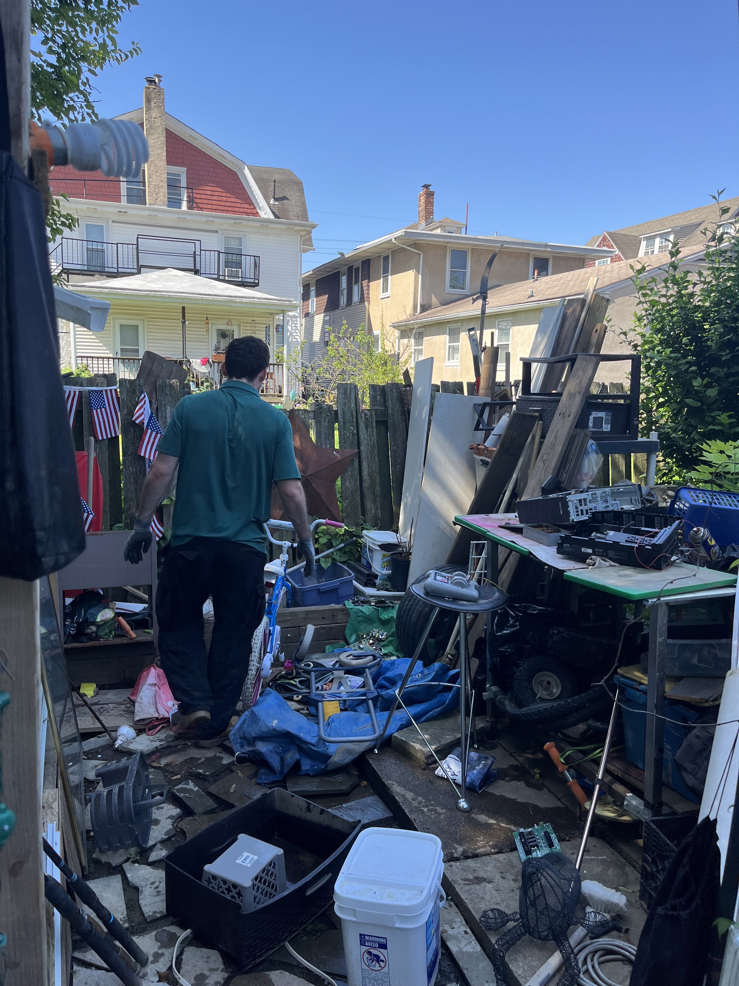 Local junk removal company in Philadelphia loading unwanted appliances and scrap into a branded hauling truck