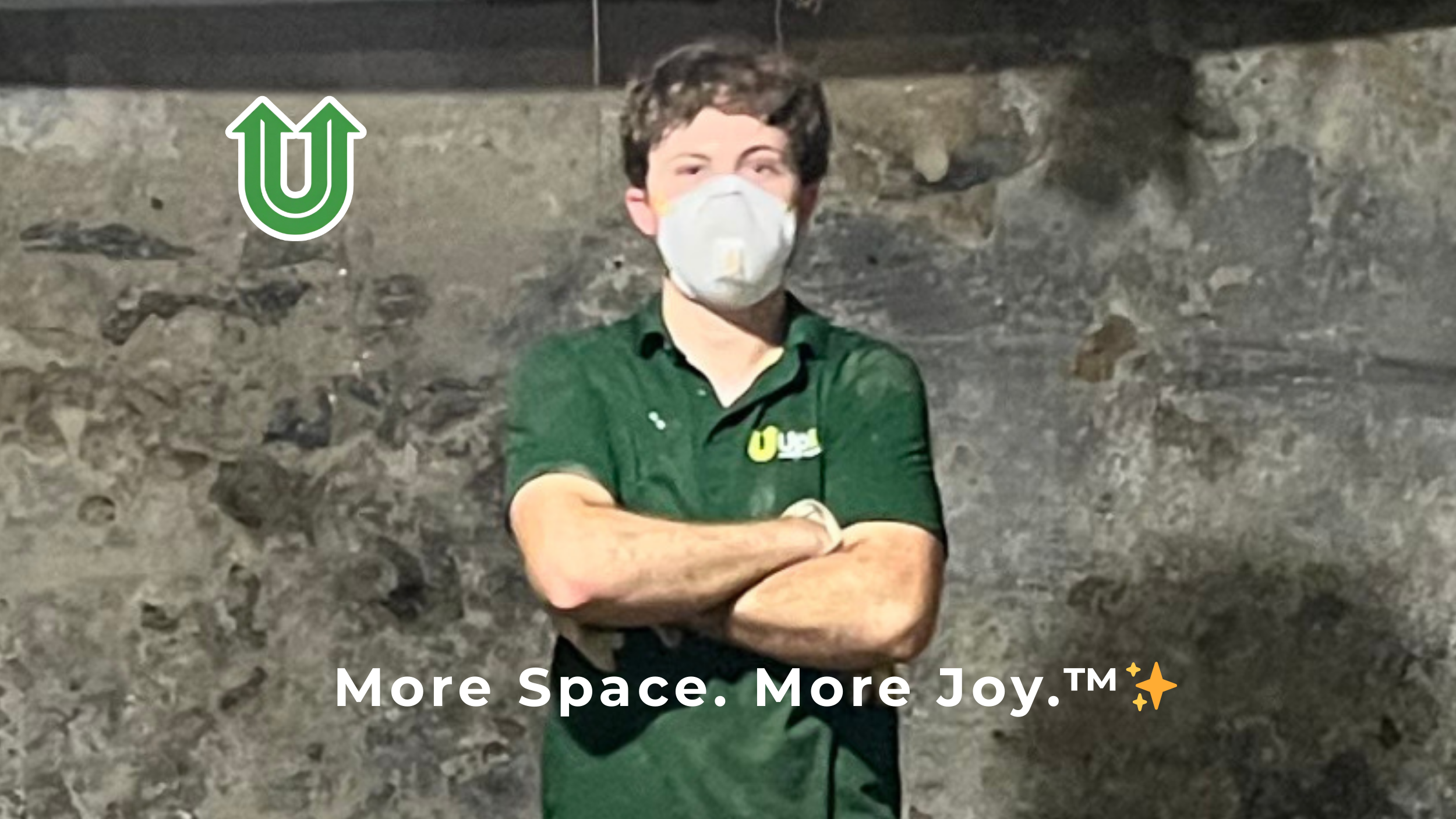 Branded photo from Uplift Junk Solutions showing founder Tristan with a safety mask giving a thumbs-up during a basement clearout on the Main Line, PA. The image features the green Uplift “U” brand mark and the ‘More Space. More Joy.™ ✨’ tagline.