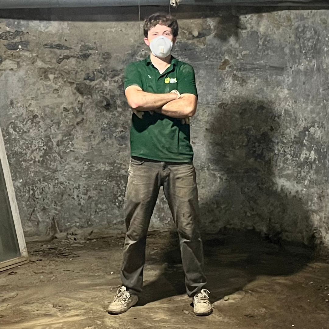 Tristan, Uplift Junk Solutions founder, wearing safety mask and giving the two thumbs up in a basement clearout in the Main Line, PA.