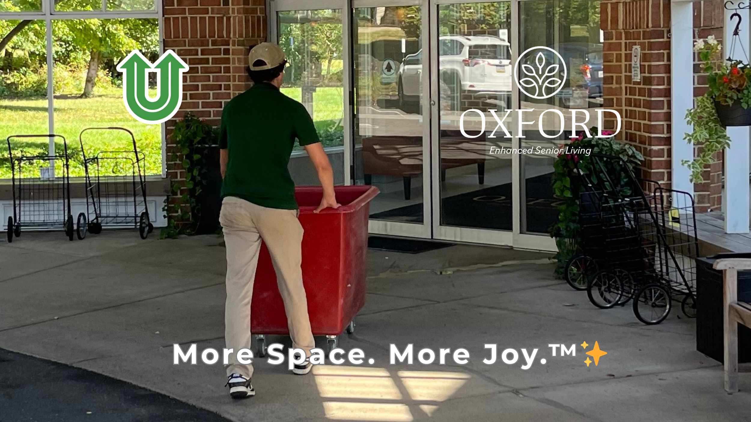 Branded photo from Uplift Junk Solutions showing a professional crew member moving a bin at Oxford Enhanced Senior Living in Langhorne, Bucks County. Features the Uplift "U" brand mark and the 'More Space. More Joy.™ ✨' tagline.