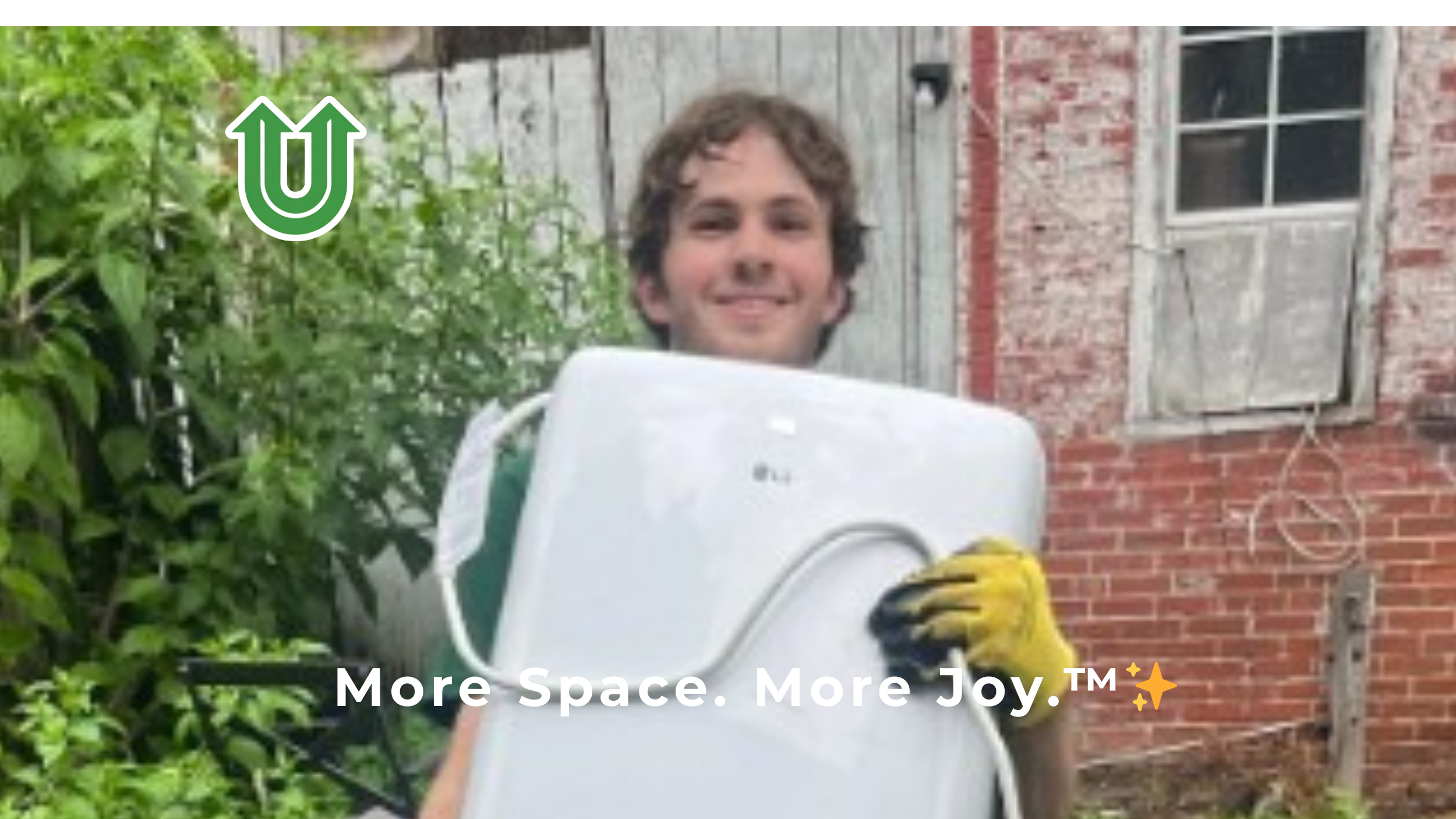 Branded photo from Uplift Junk Solutions showing founder Tristan removing an old washing machine from a home in the Pennsylvania suburbs. The image features the green Uplift “U” brand mark and the ‘More Space. More Joy.™ ✨’ tagline.