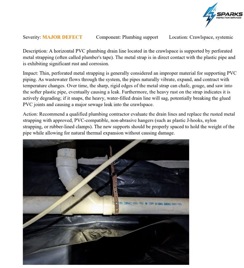 Inspection report on plumbing support identifying a cracked PVC drain line supported by a metal strap with rust, located in crawlspace.