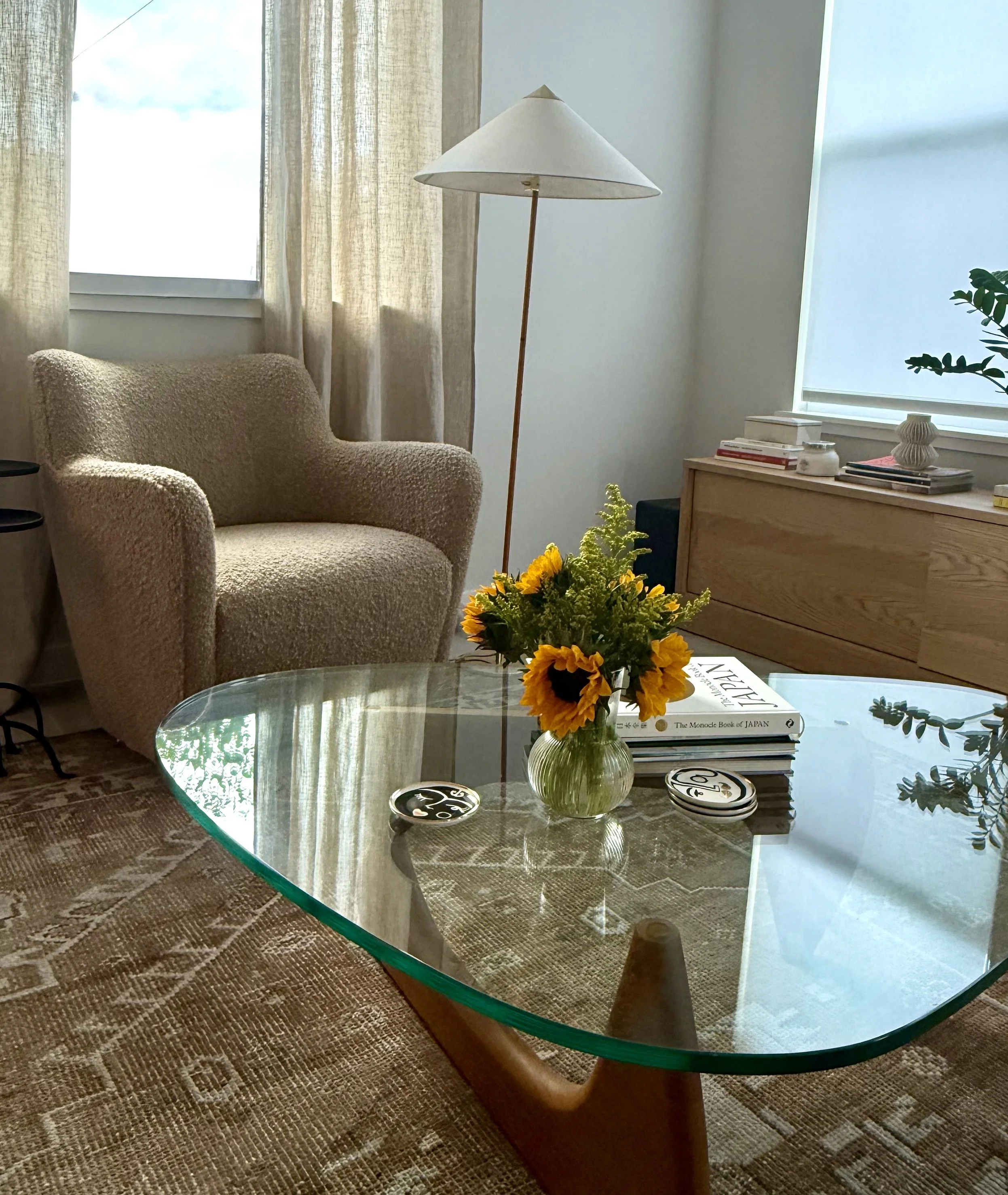 Gubi floor lamp, warm texture lounge chair, classic Persian vintage rug.