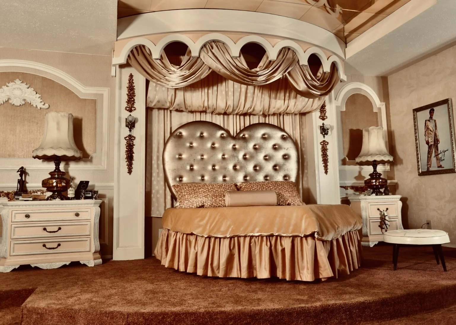 Zombieland movie set with a large heart tufted headboard, lavish drapery, ornate furniture, and vintage decor called the Hound dog hotel.