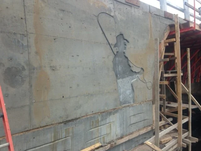  A close up of the fisherman carving located on one side of the Northwest River Bridge. Like the fish, this piece is infilled with black on the final bridge, providing the bridge with some unique character.  