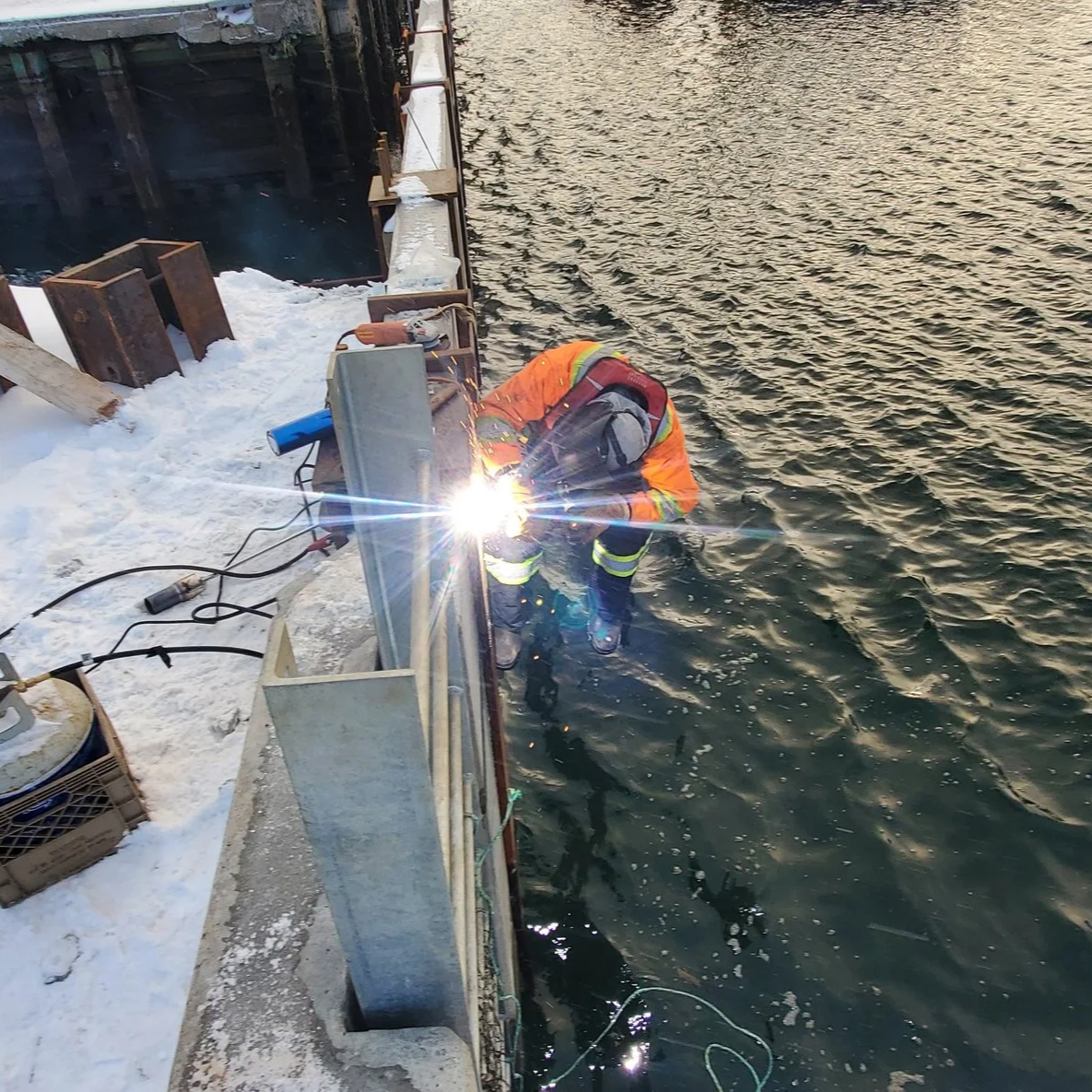 One of our welders working "harbour side" to repair damage sustained to a pier. Structural welding done with precision and excellence.