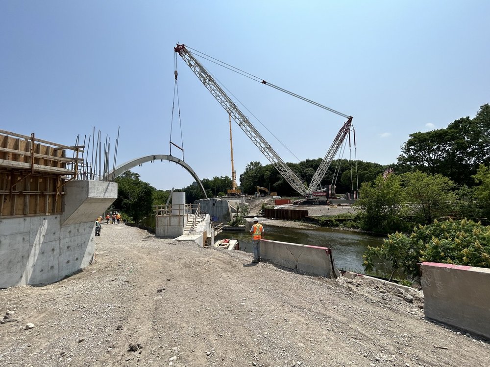 Crane moving arch into position over River